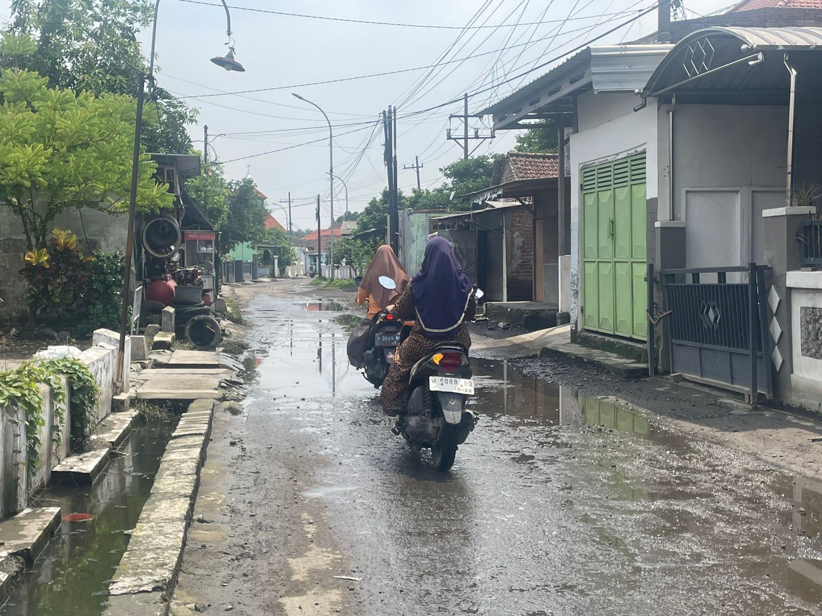 PELAN-PELAN: Banjir yang terjadi di Jalan Desa Bringin Kulon RW 03 Desa Bringinbendo sudah surut. (M SAIFUL ROHMAN/RADAR SIDOARJO)