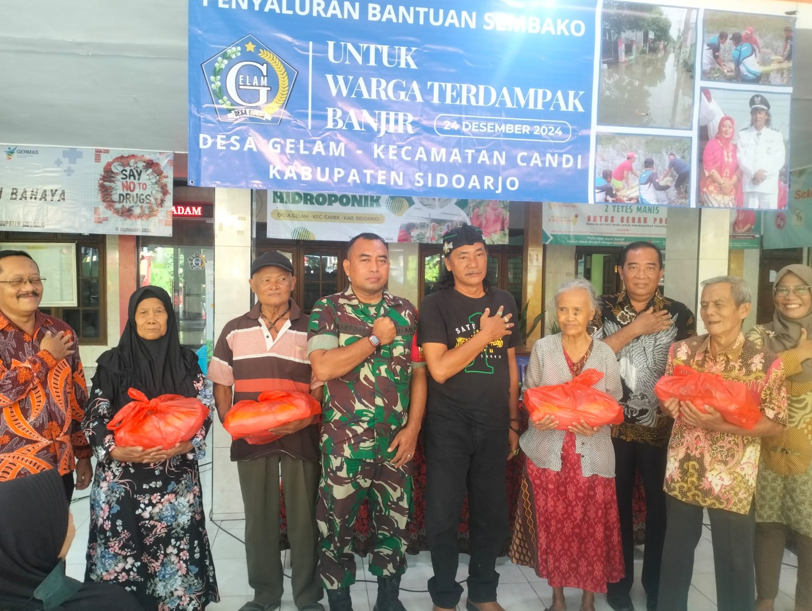 SINERGIS: Foto bersama Kades Gelam Muchammad Muslich (tengah) bersama warga yang terdampak banjir. (ANAS/RADAR SIDOARJO)