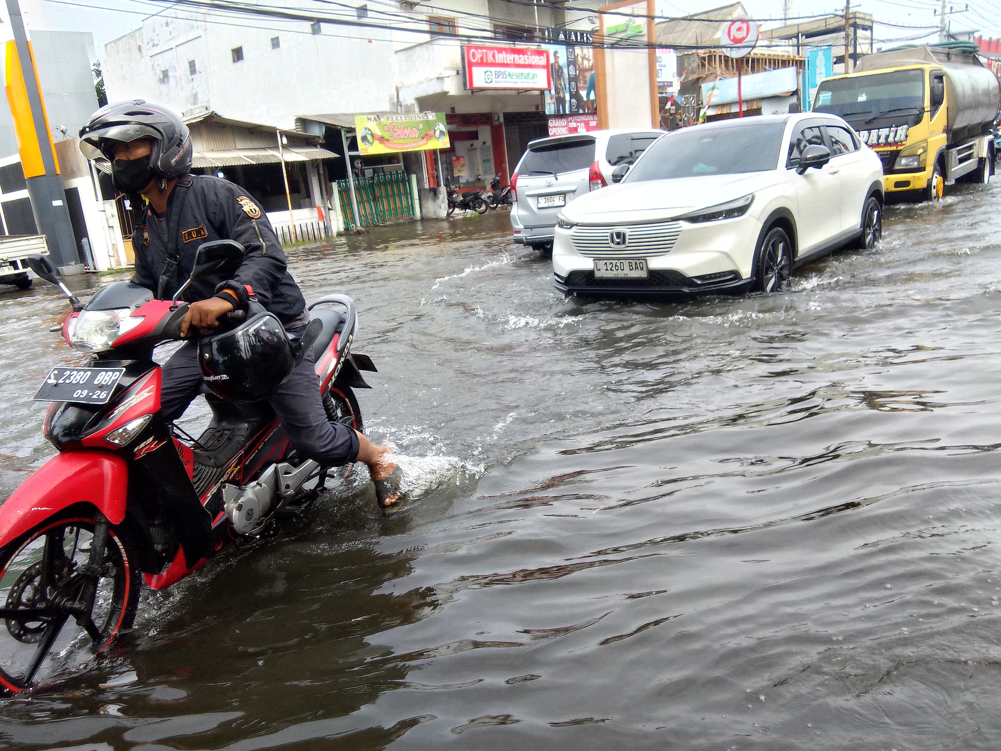 BELUM SURUT : Banjir menggenang di Jalan Raya Tropodo, Rabu (25/12). (DIKY PUTRA SANSIRI/RADAR SIDOARJO)