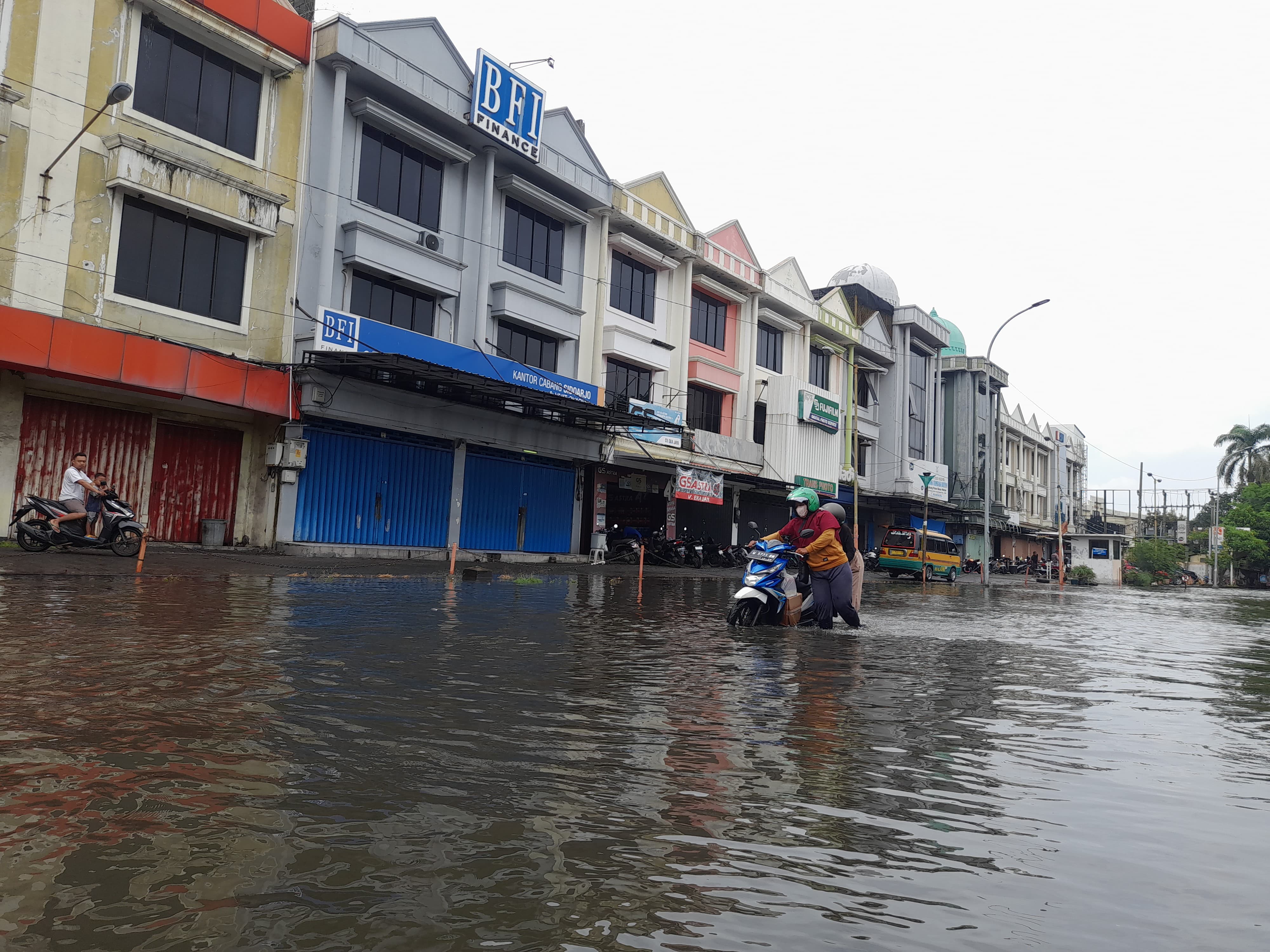 TERGENANG: Banjir yang terjadi di Desa Pepelegi, Kecamatan Waru membuat aktivitas pengguna jalan terganggu. (M SAIFUL ROHMAN/RADAR SIDOARJO)