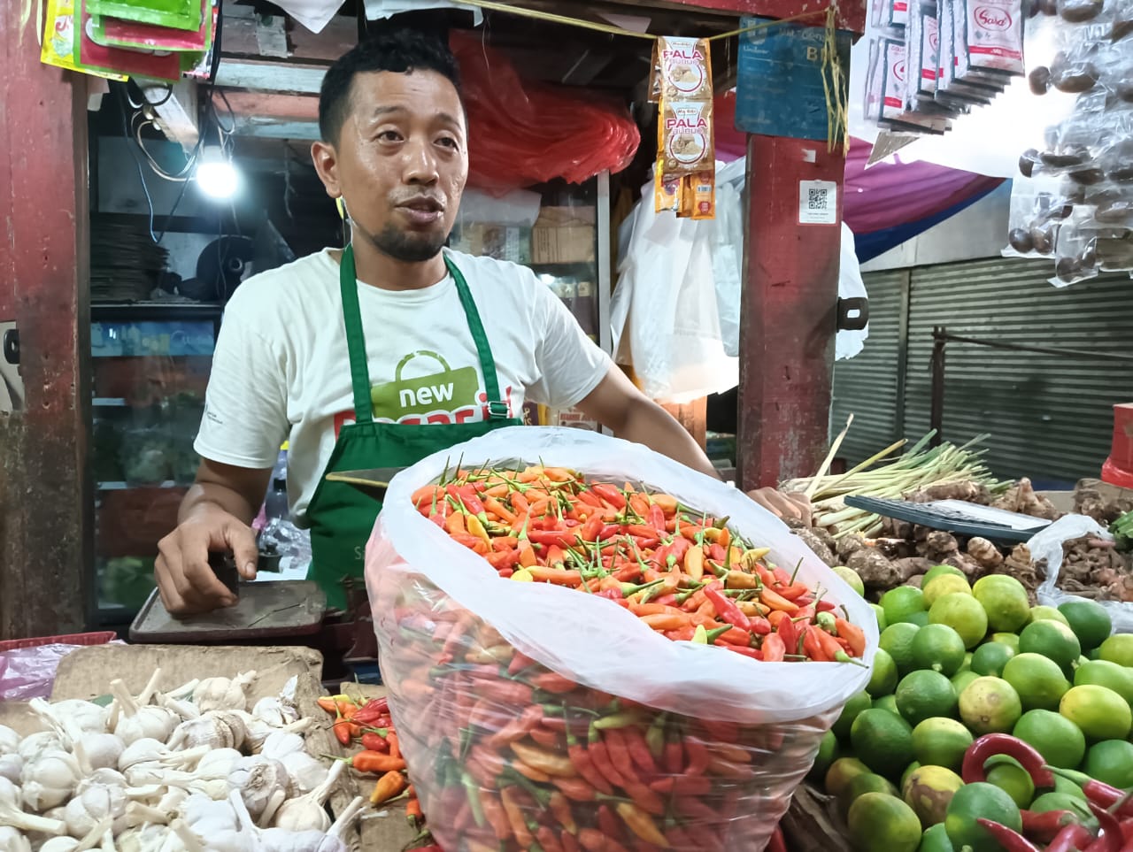 MELONJAK: Salah satu pedagang di Pasar Larangan, Sidoarjo, menunjukkan cabai rawit yang dijualnya. (M SAIFUL ROHMAN/RADAR SIDOARJO)