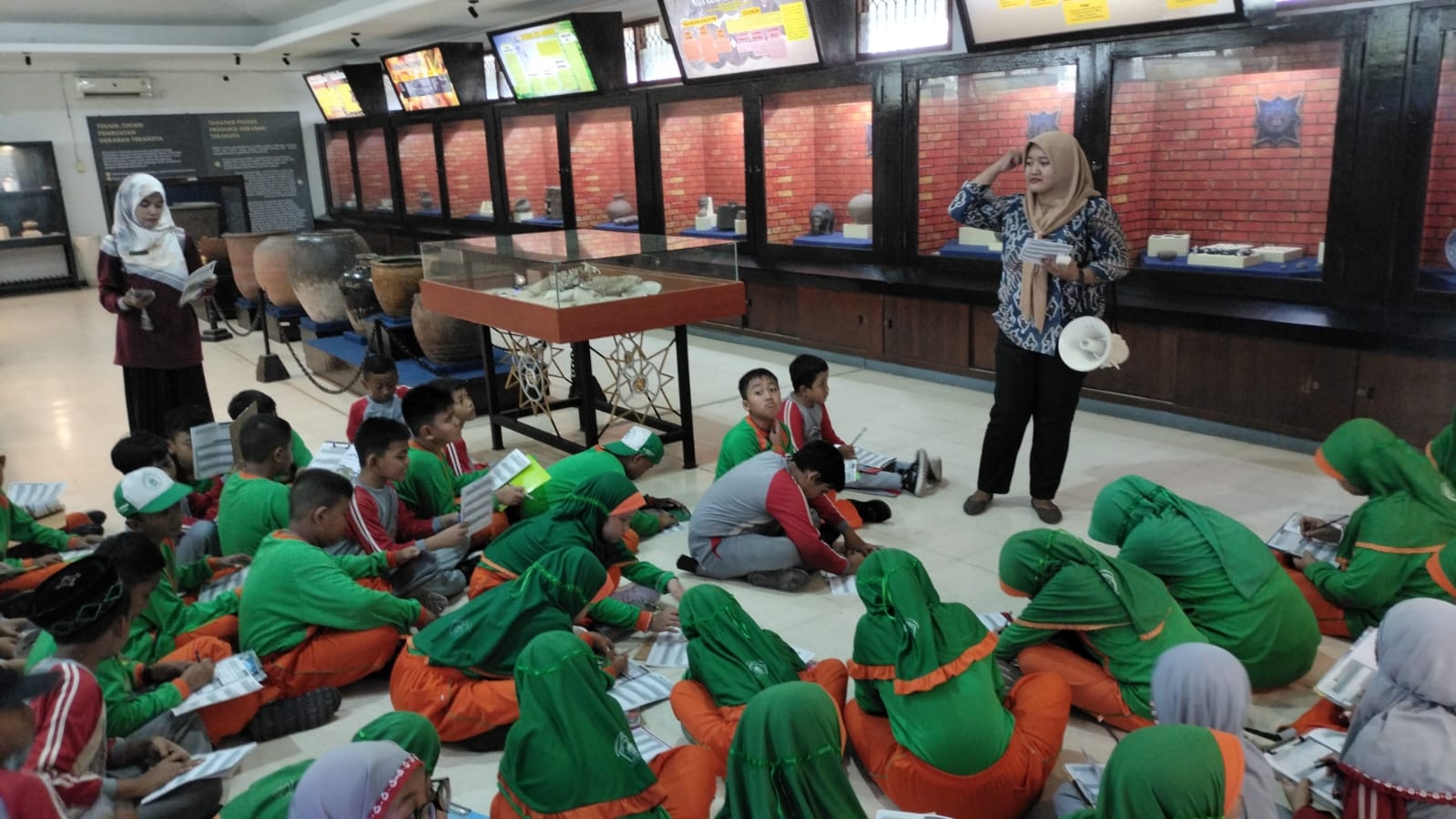 EDUKASI: Para siswa kelas IV MI Darussalam Sugihwaras, Sidoarjo, saat diberi arahan oleh pemandu dari Museum Trowulan. (IST/RADAR SIDOARJO)