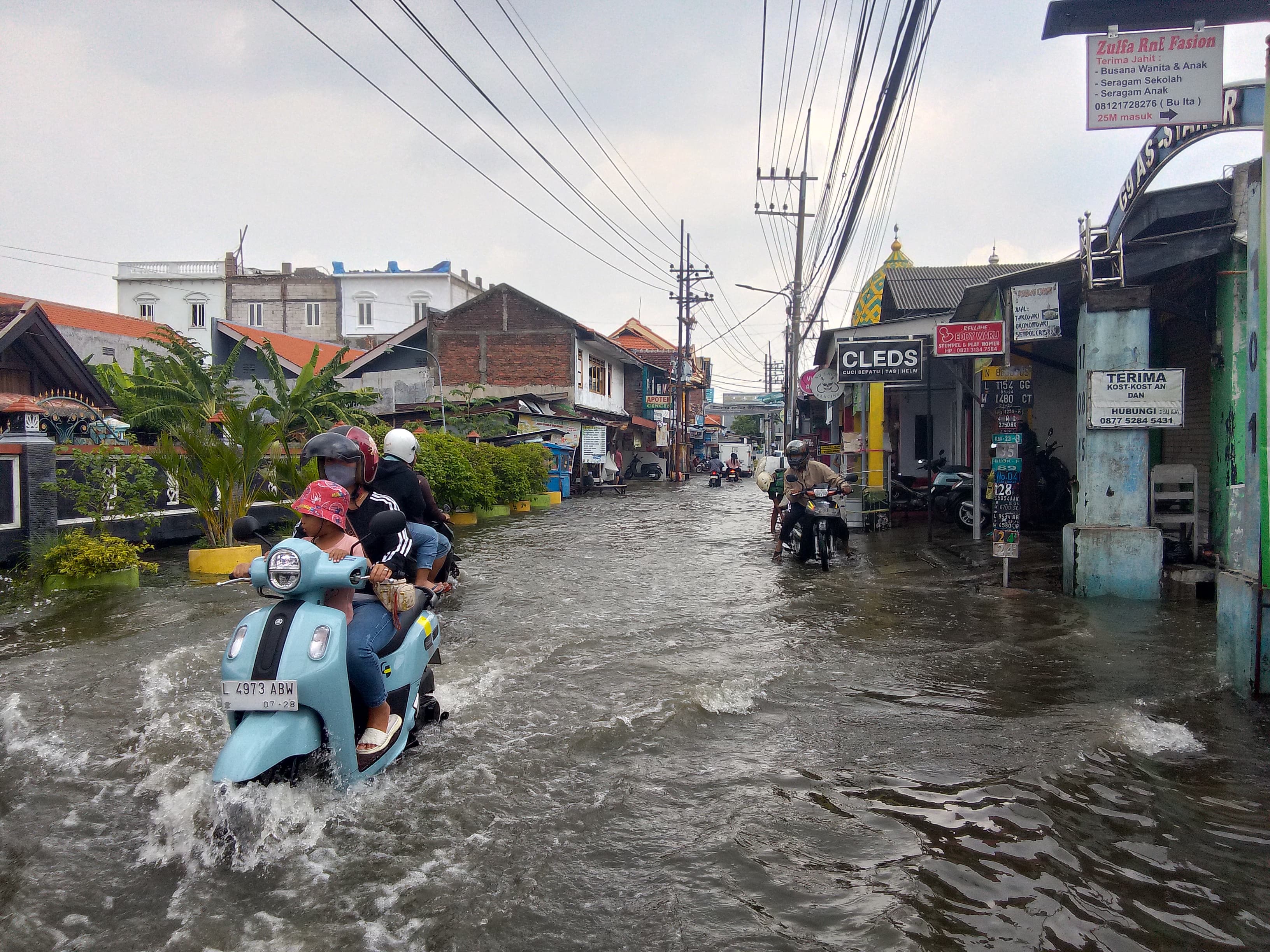 TERGENANG: Banjir yang terjadi di Desa Medaeng, Kecamatan Waru, Sidoarjo, membuat aktivitas pengguna jalan terganggu, Rabu (15/1). (DIKY PUTRA SANSIRI/RADAR SIDOARJO)