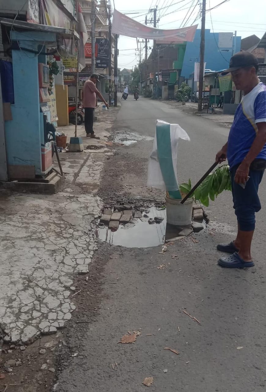 BERLUBANG : Jalan Joyoboyo, Sawotratap, Gedangan, Sidoarjo, rusak karena banjir, Rabu (15/1). (DIKY PUTRA SANSIRI/RADAR SIDOARJO)