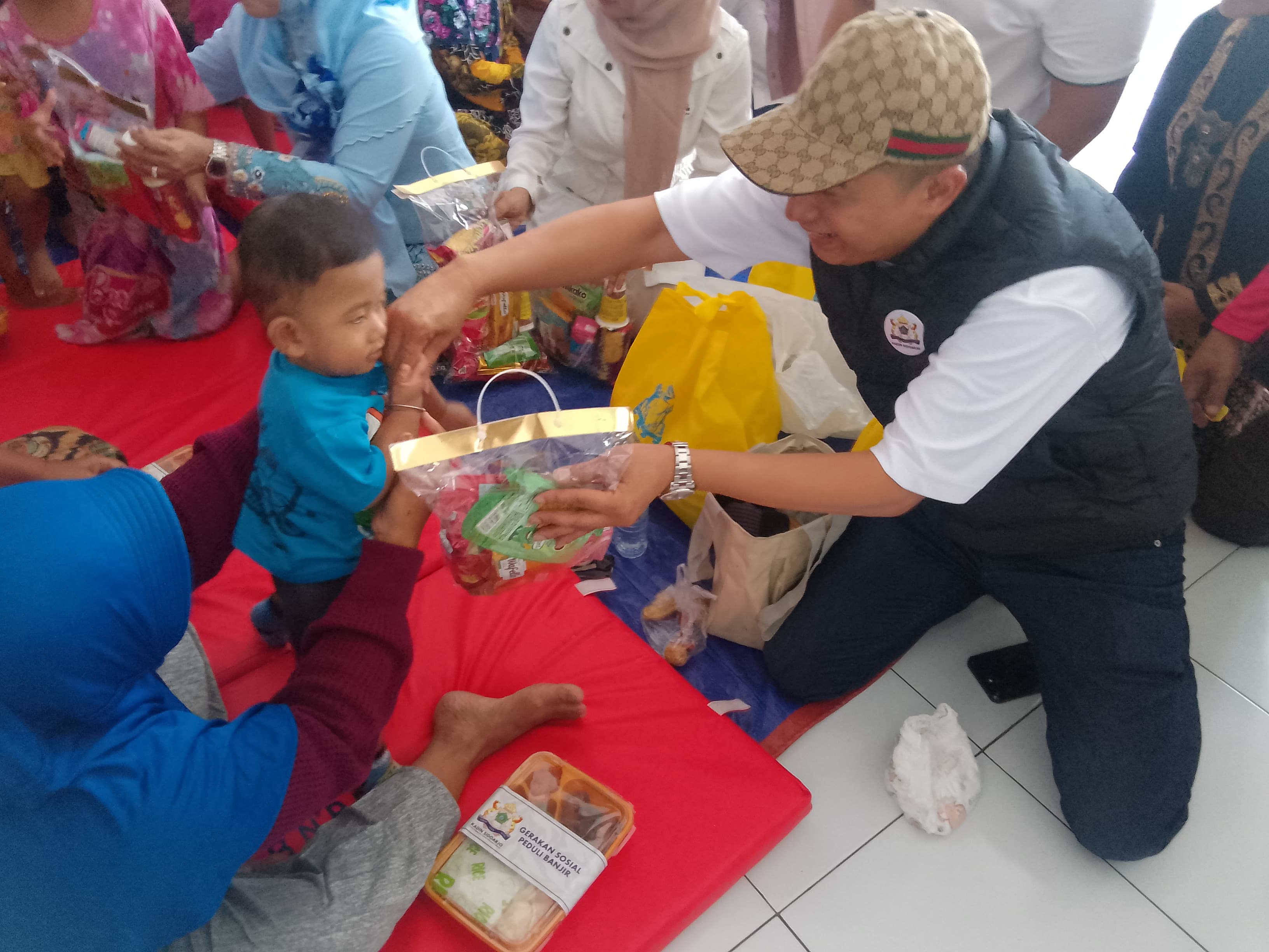 PEDULI : Ketua Kadin Sidoarjo Ubaidillah Nurdin bersama Sekda Sidoarjo, Fenny Apridawati bagikan sembako ke warga Kedungbanteng, Tanggulangin, Jumat (31/1). (DIKY PUTRA SANSIRI/RADAR SIDOARJO)