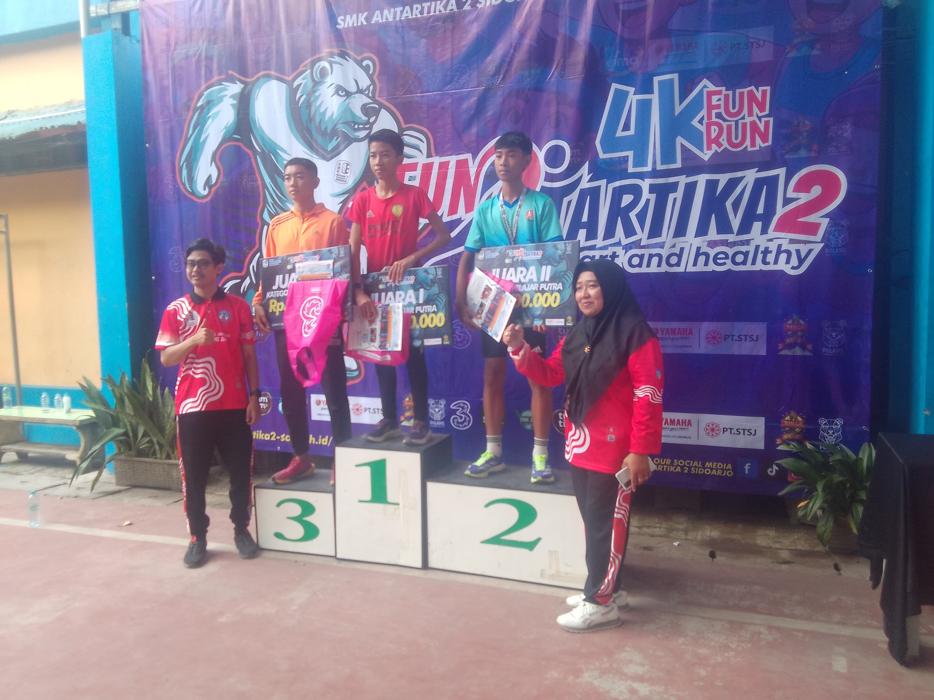PRESTASI: Kepala SMK Antartika 2, Retno Purwolystiorini dan Ketua Pelaksana, Arbi Wahyu Eko Jati memberikan hadiah untuk peserta Juara 1, 2, dan 3 kategori pelajar laki-laki. (ANAS/RADAR SIDOARJO)  &nbsp;