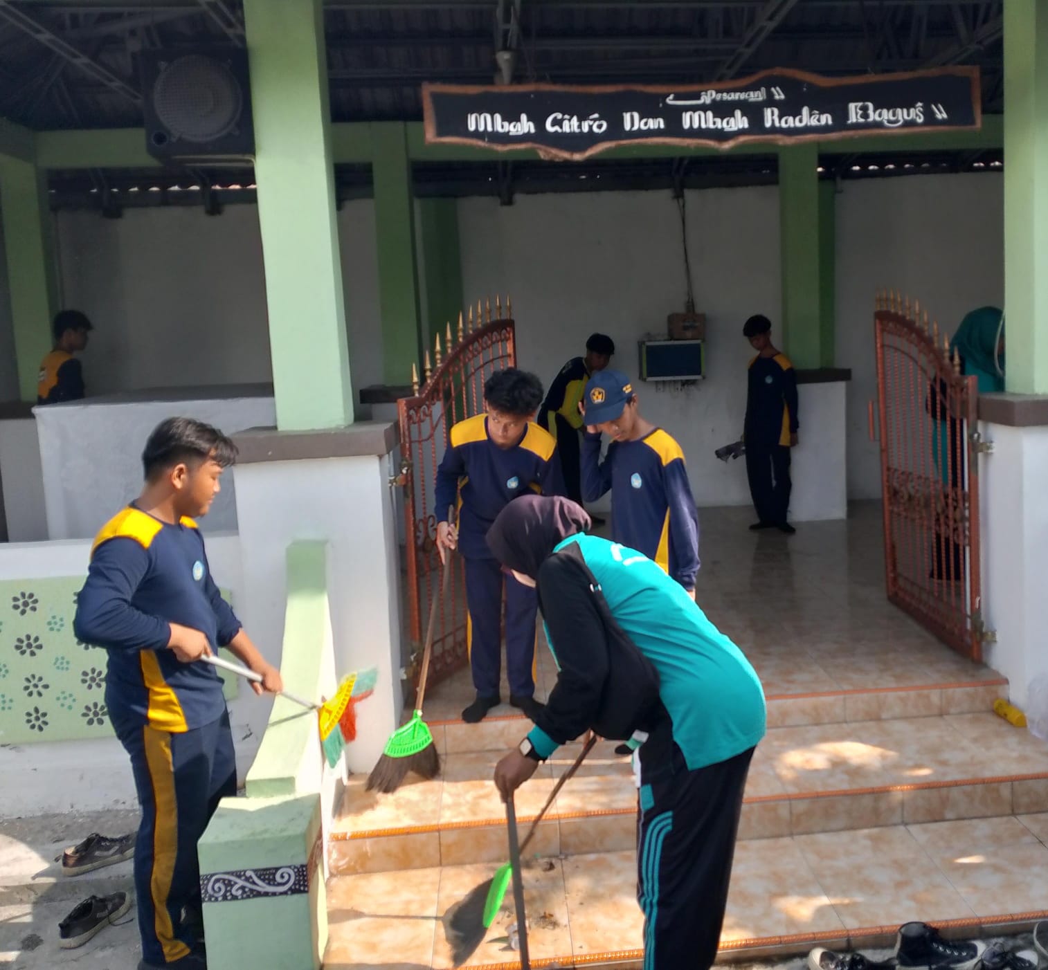 AKSI NYATA: Civitas SMPN 1 Buduran saat melaksanakan aksi pengabdian masyarakat dengan kerja bakti membersihkan area pesarean Mbah Citro. (INDRA WIJAYANTO/RADAR SIDOARJO)