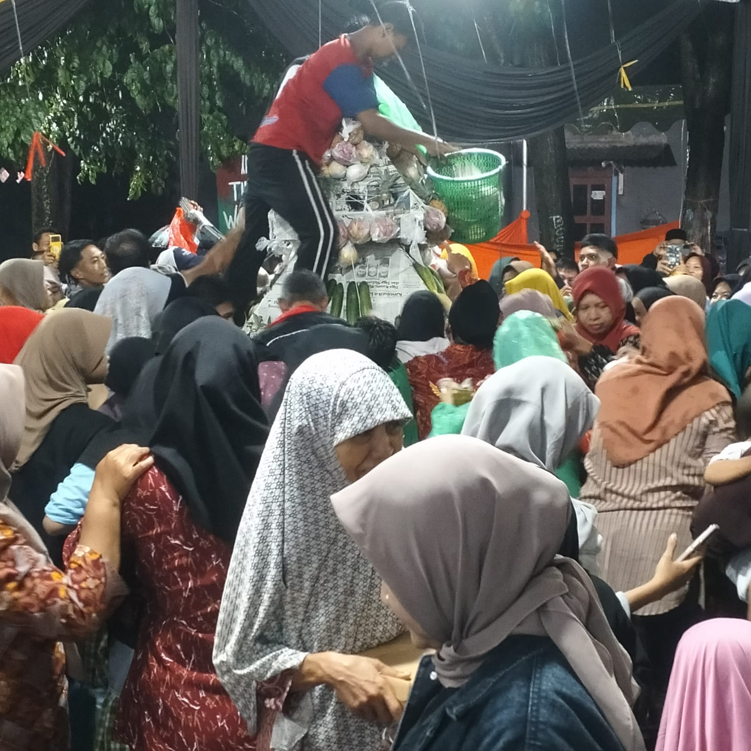 MERIAH : Warga Desa Gelam berebut sayur, buah-buahan peralatan dapur dan lain sebagainya dalam ruwat desa setempat. (ANAS/ RADAR SIDOARJO)