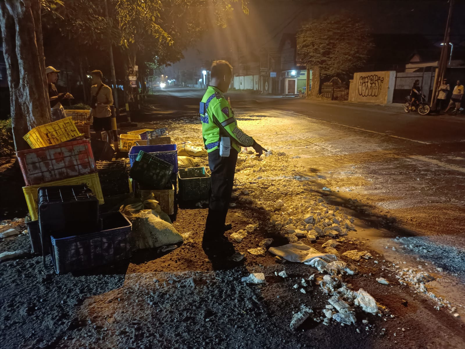 RINGSEK : Polisi menunjukkan lokasi pikap muat tahu yang terguling di Jalan Raya Jabaran, Balongbendo, Sidoarjo, Senin (3/3). (IST/RADAR SIDOARJO)