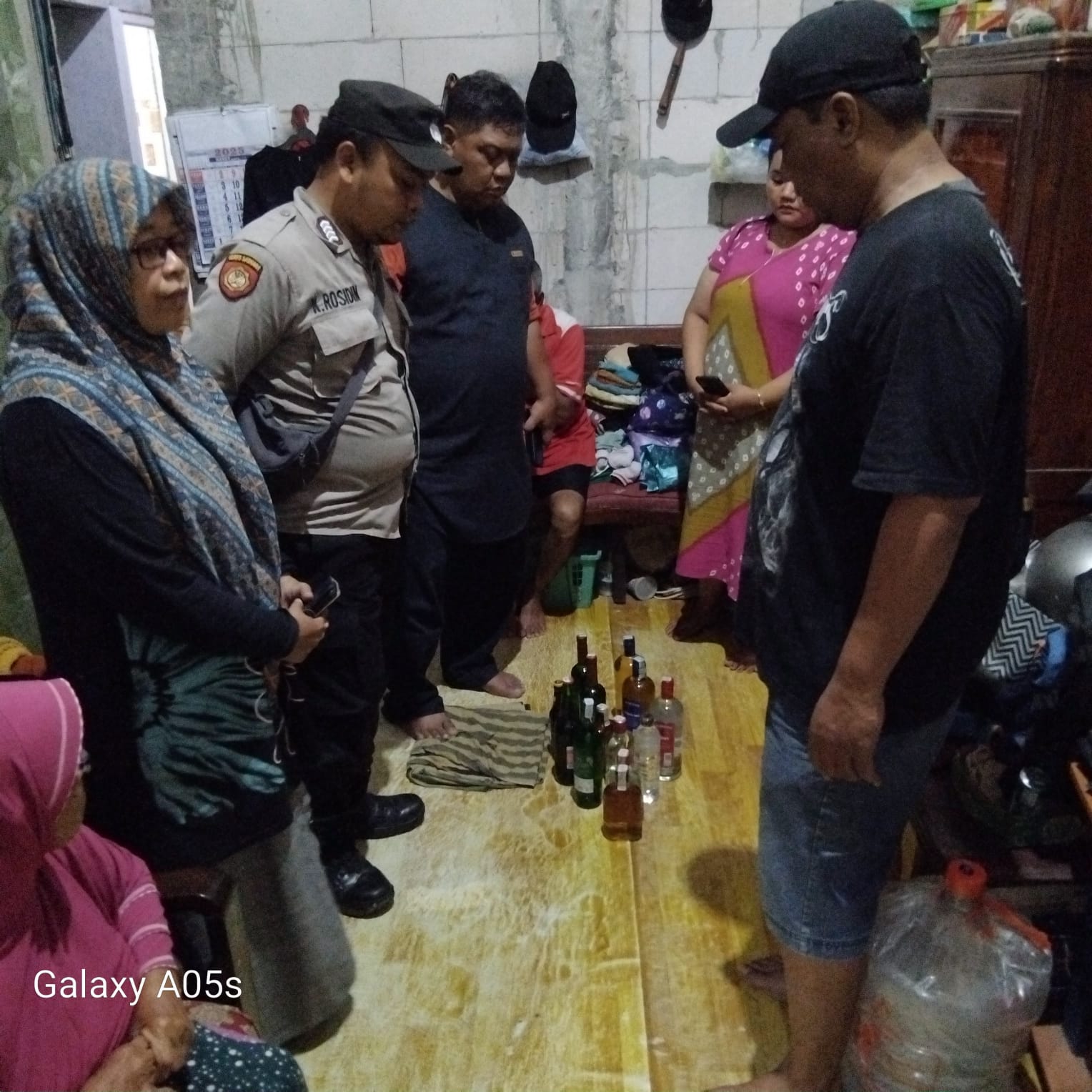 DIAMANKAN : Polisi saat mendatangi rumah yang menjual miras di Desa Karangbong, Gedangan, Sidoarjo. (IST/RADAR SIDOARJO)
