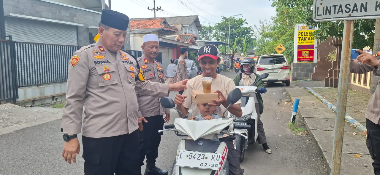 SUMRINGAH : Pengendara dan warga sekitar Polsek Taman antrean untuk mendapat takjil. (GUNTUR IRIANTO/RADAR SIDOARJO)