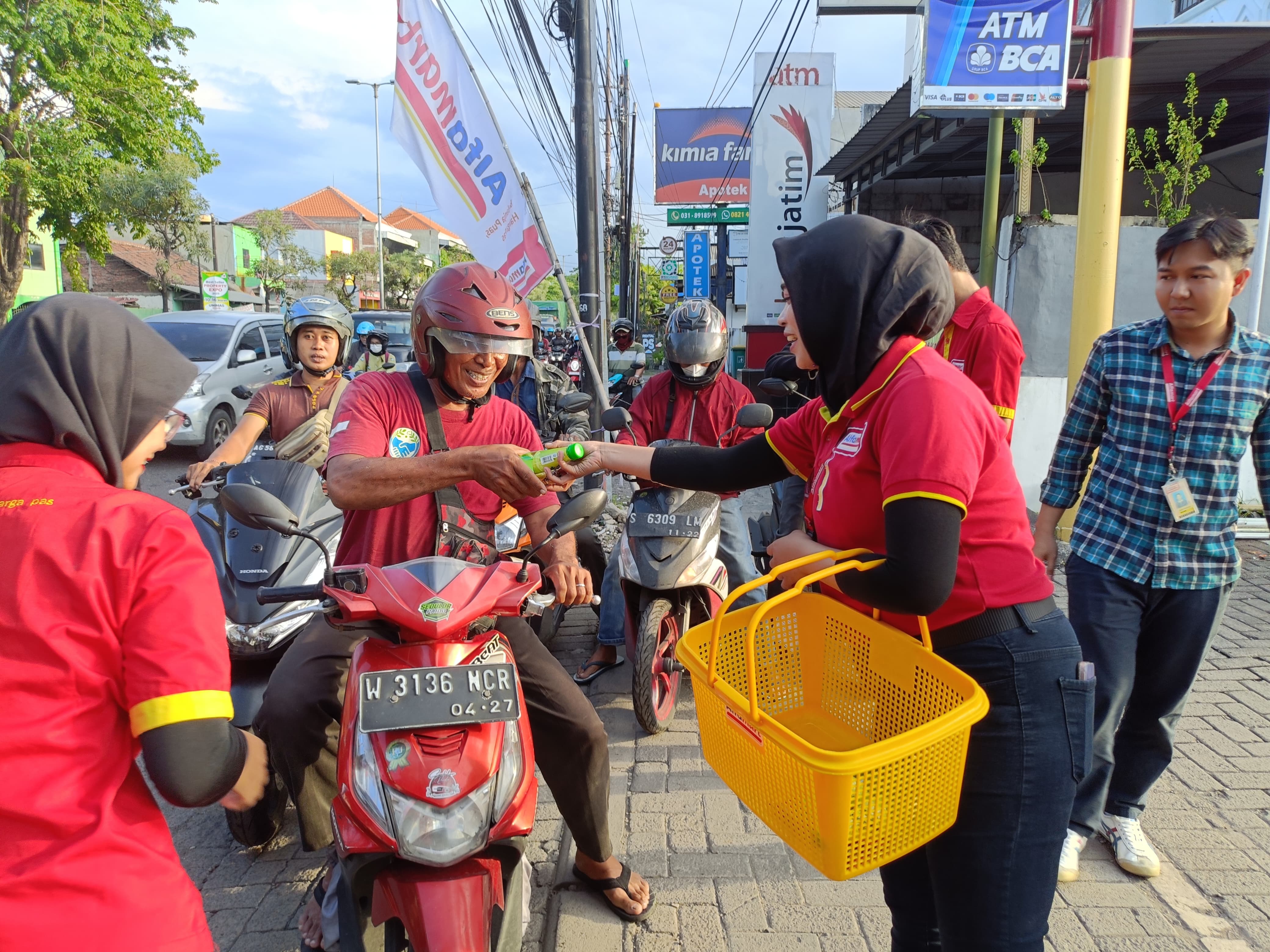 BERBAGI: Ada 300 paket yang dibagikan pada pengguna jalan yang melintas di depan Toko Alfamart Gedangan dan Toko Alfamart Ganting, Selasa (11/3/2025).
