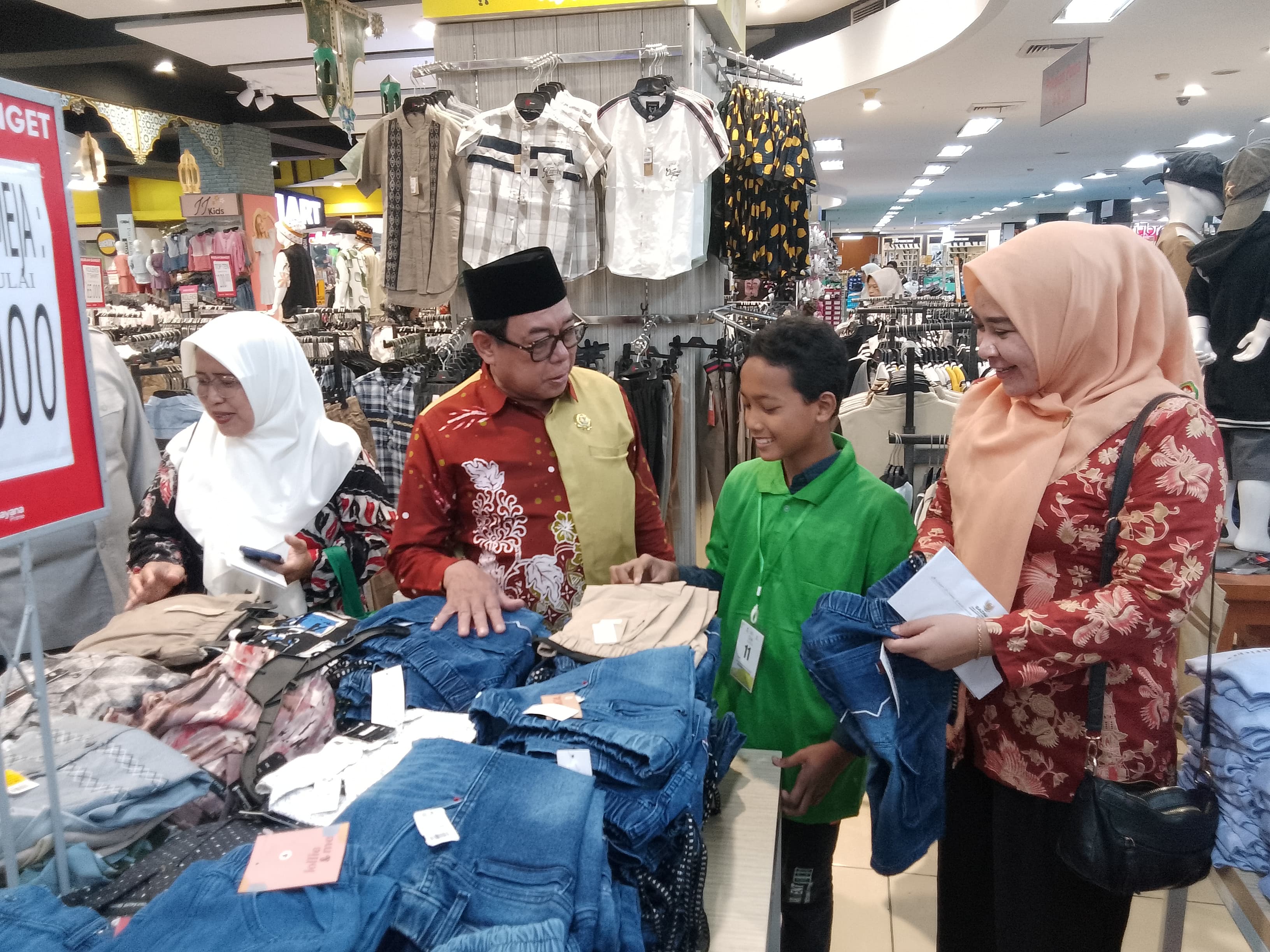BERBAGI KEBAHAGIAAN : Ketua BAZNAS Jatim KH Ali Maschan Moesa saat mendampingi anak yatim memilih baju Lebaran, Selasa (11/3). (DIKY PUTRA SANSIRI/RADAR SIDOARJO)