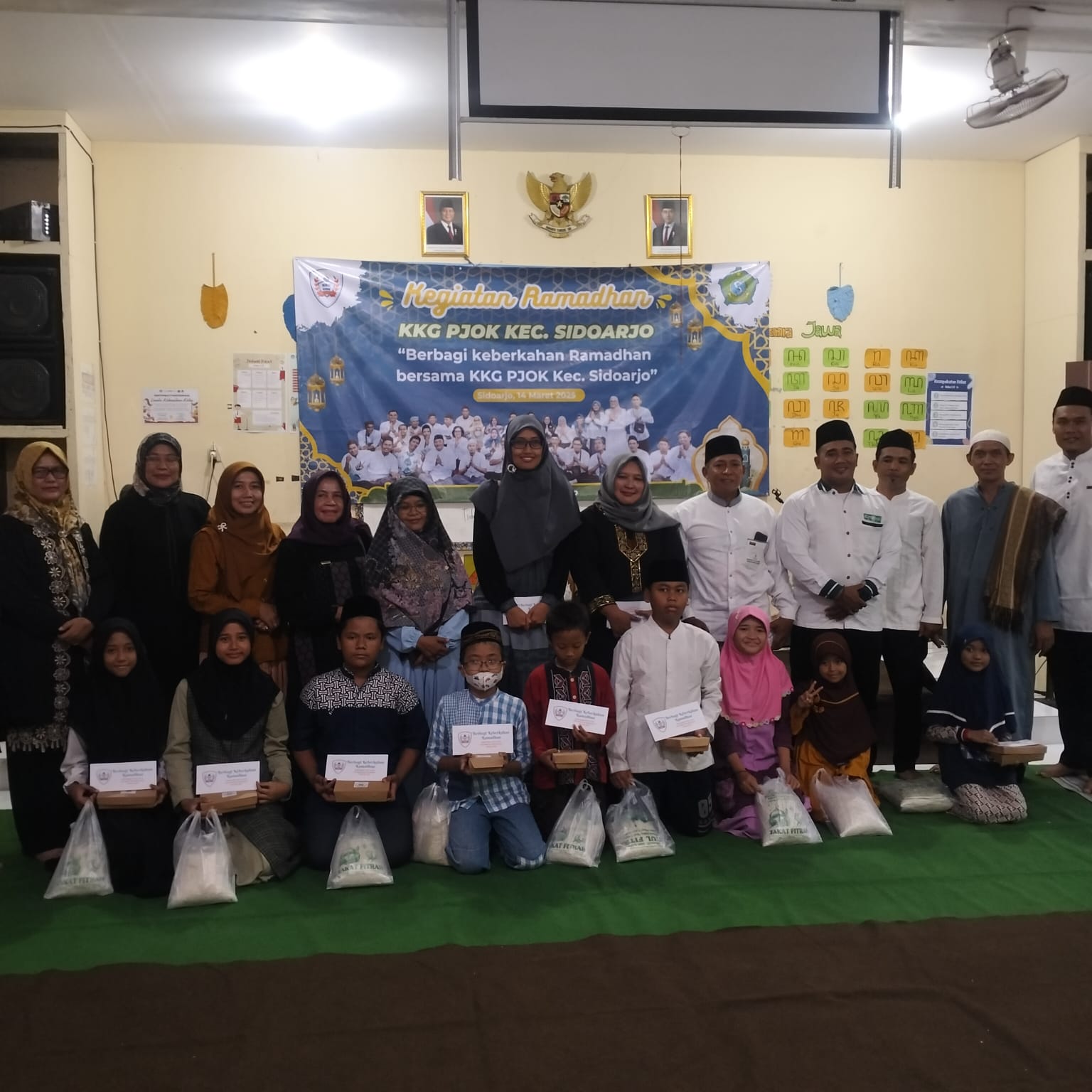 KOMPAK: KKG PJOK kecamatan Sidoarjo saat membagikan beras dan uang kepada siswa anak yatim dan dhuafa. (ANAS/RADAR SIDOARJO)