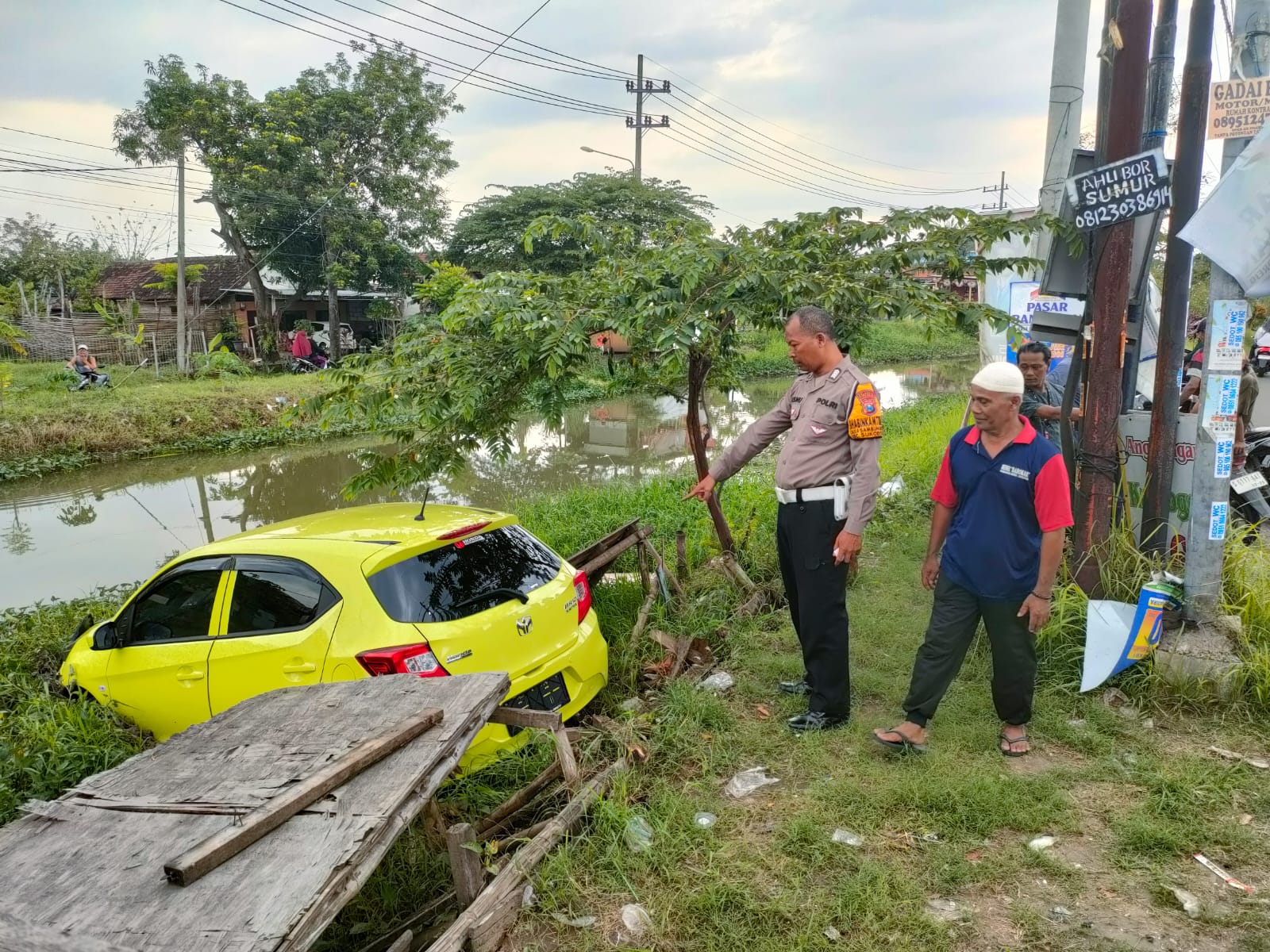 APES : Mobil kuning tercebur ke sungai di Jalan Raya Masanganwetan, Sukodono, Selasa (18/3). (IST/RADAR SIDOARJO)