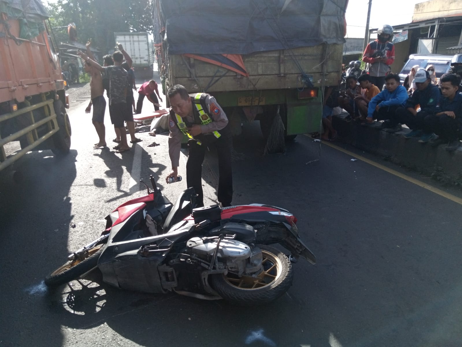 TONTONAN : Petugas sedang mengevakuasi korban kecelakaan maut di Jalan Raya Desa Suwaluh, Balongbendo, Sidoarjo, Kamis (20/3). (IST/RADAR SIDOARJO)