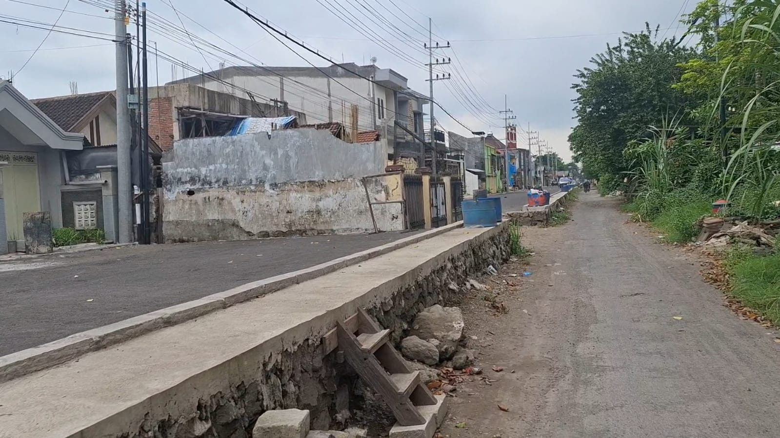 TERHALANG: Nampak sebuah rumah masih berdiri di tengah Jalan Frontage Road Buduran, Sidoarjo. (M SAIFUL ROHMAN/RADAR SIDOARJO)