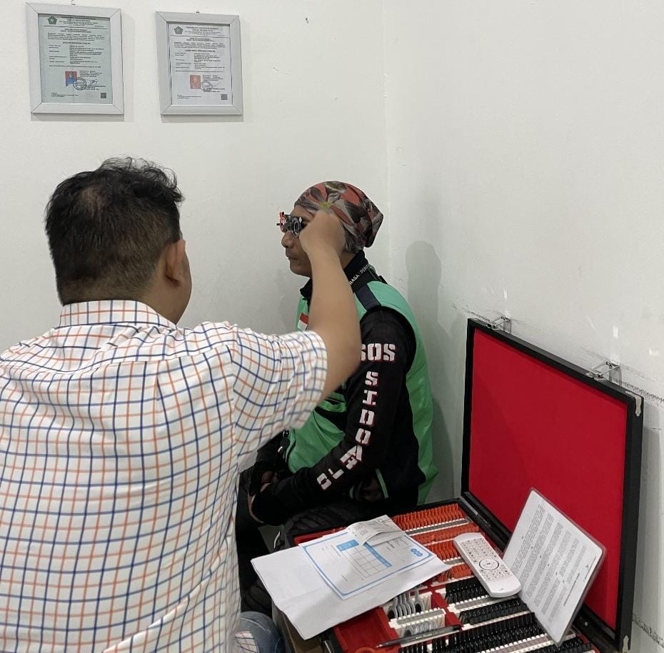 PEMERIKSAAN: Salah satu pengendara ojol saat melakukan pemeriksaan mata untuk mendapat resep kacamata baru. (IST/RADAR SIDOARJO)