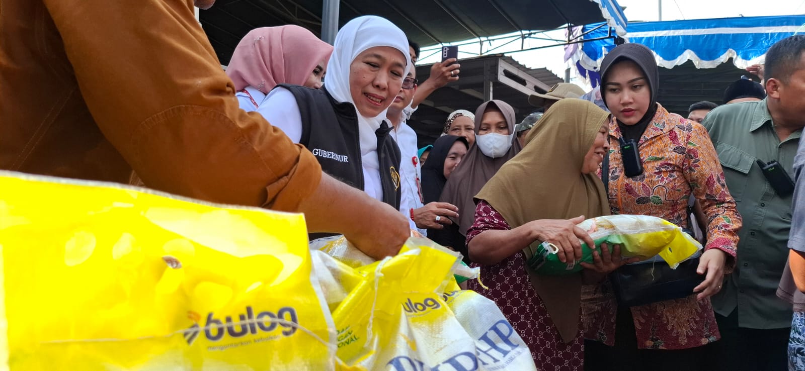 STABIL : Gubernur Jawa Timur Khofifah Indar Parawansa saat membagikan beras untuk masyarakat di Pasar Murah Sedati, Sidoarjo. (M SAIFUL ROHMAN/RADAR SIDOARJO)