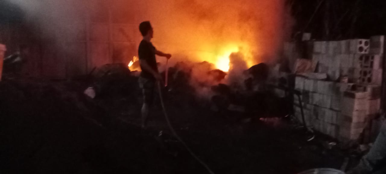 MENYALA : Petugas Damkar saat memadamkan api yang membakar gudang bahan baku tas di Desa Kedensari, Tanggulangin, Sidoarjo, Selasa (22/4). (IST/RADAR SIDOARJO)