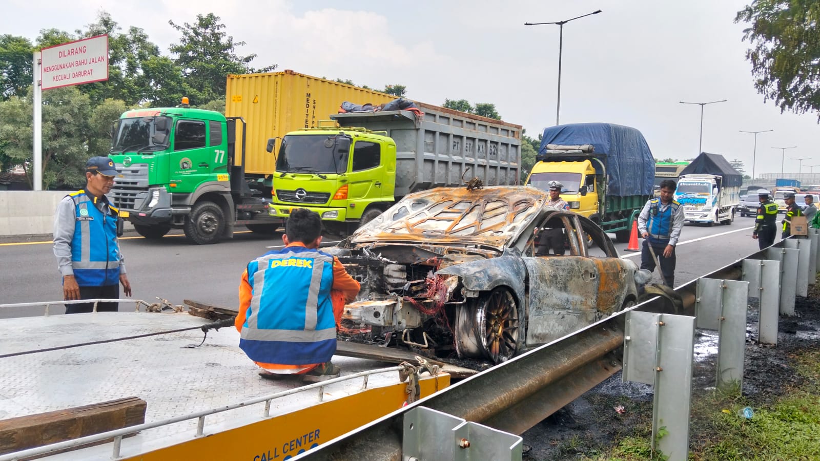 EVAKUASI: Kondisi mobil usai terbakar di tol Sidoarjo arah Waru, Selasa (22/4). (DIKY PUTRA SANSIRI/RADAR SIDOARJO)