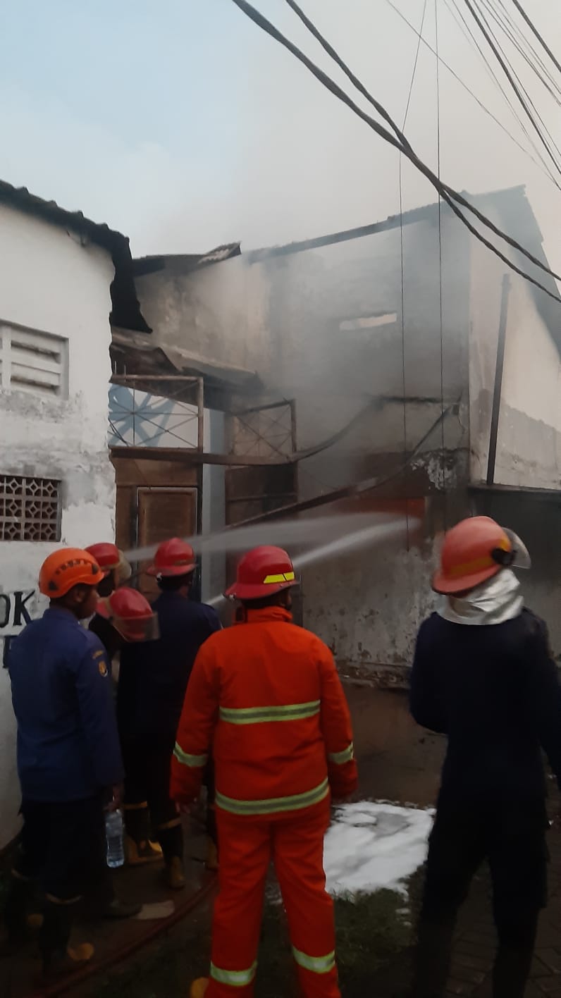 BERJIBAKU: Petugas damkar memadamkan api di gudang tiner, Taman, Senin (28/4).