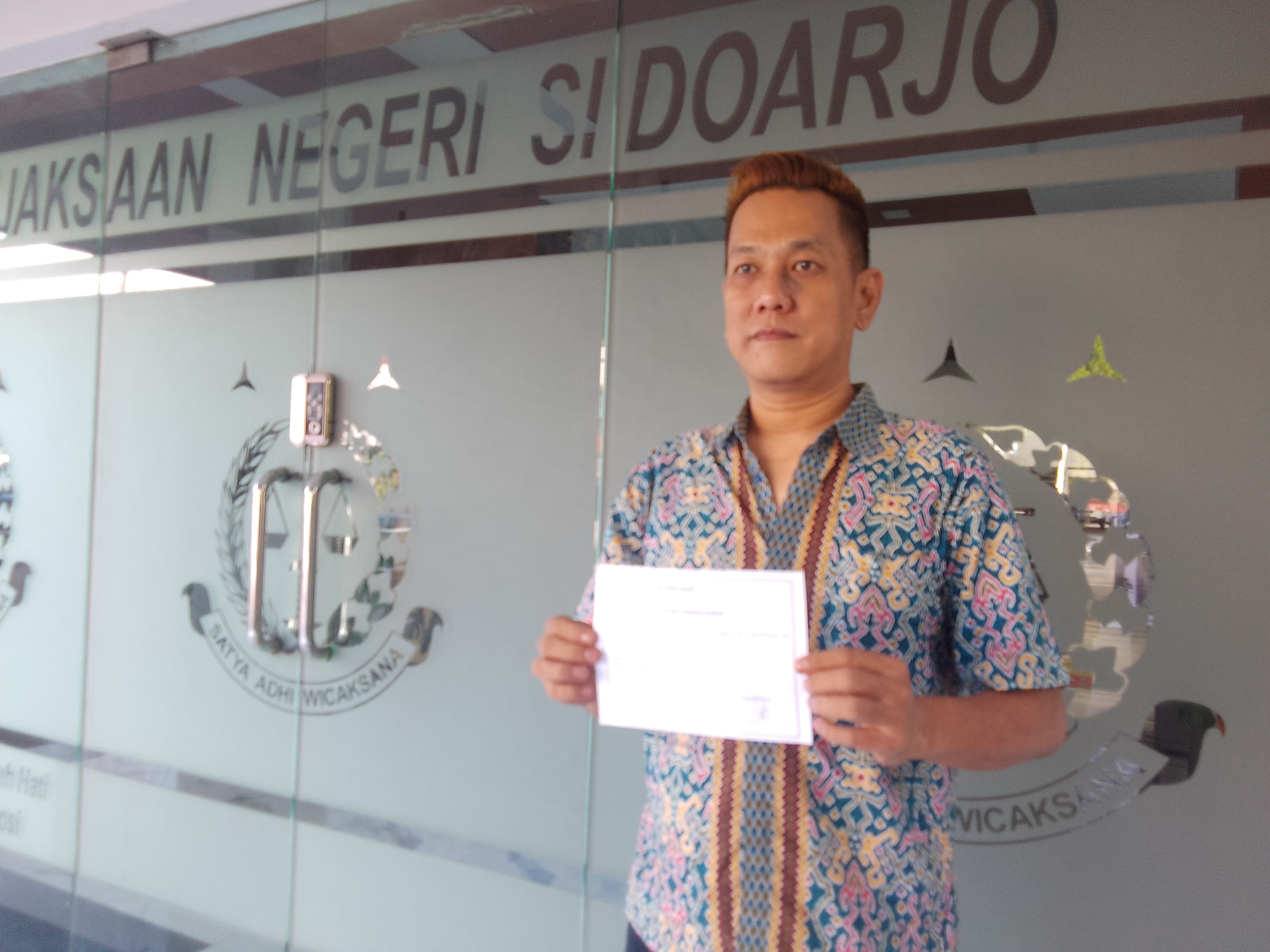 MELAPORKAN: Salah satu warga yang melaporkan, Tantri Sanjaya, saat berada di Kejari Sidoarjo, Rabu (7/5). (DIKY PUTRA SANSIRI/RADAR SIDOARJO)
