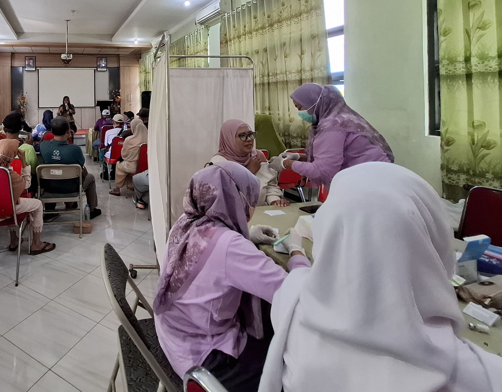 SKRINING: Petugas dari Puskesmas Porong saat memeriksa kesehatan masyarakat. (IST)