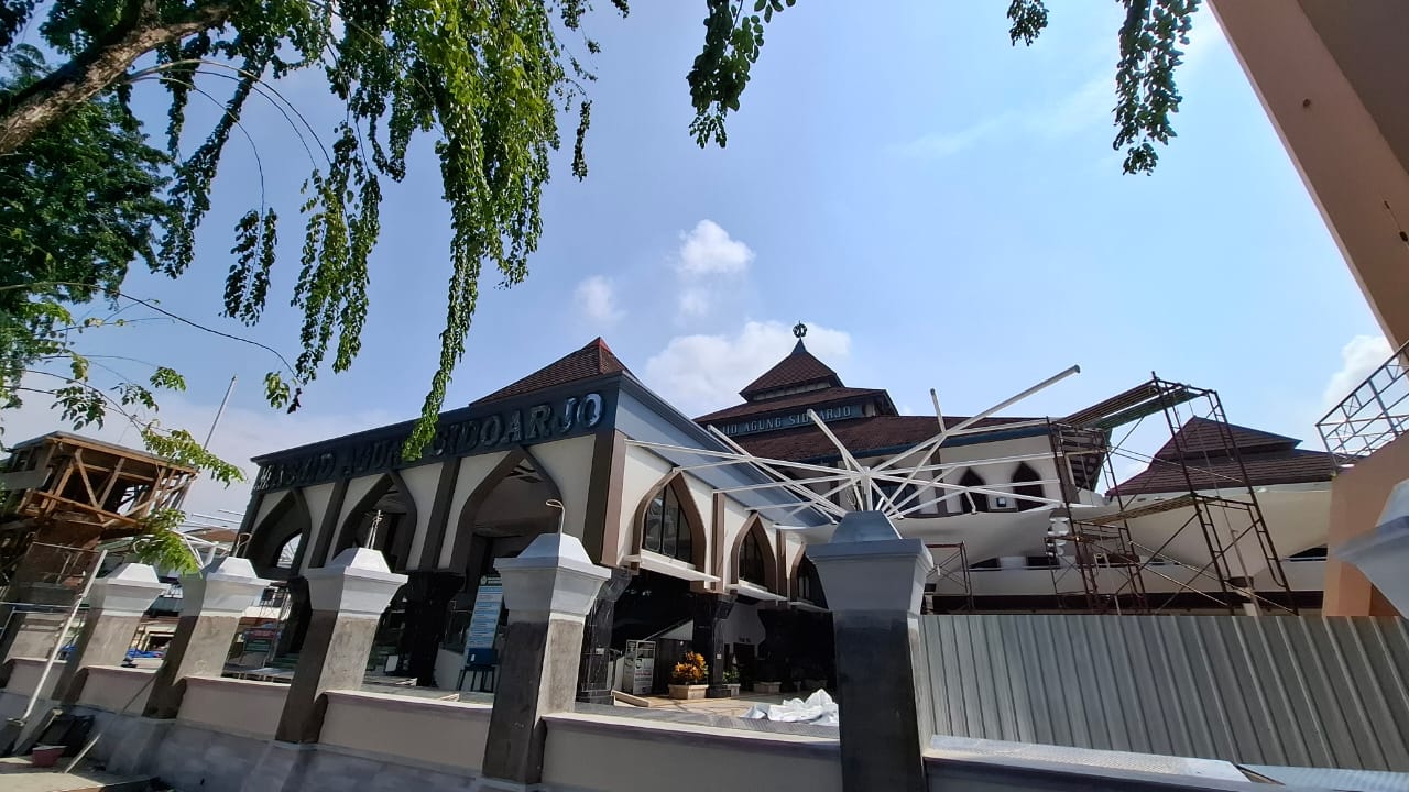 PROGRES: Proses pemasangan unit payung raksasa di pelataran Masjid Agung Sidoarjo. (M SAIFUL ROHMAN/RADAR SIDOARJO)