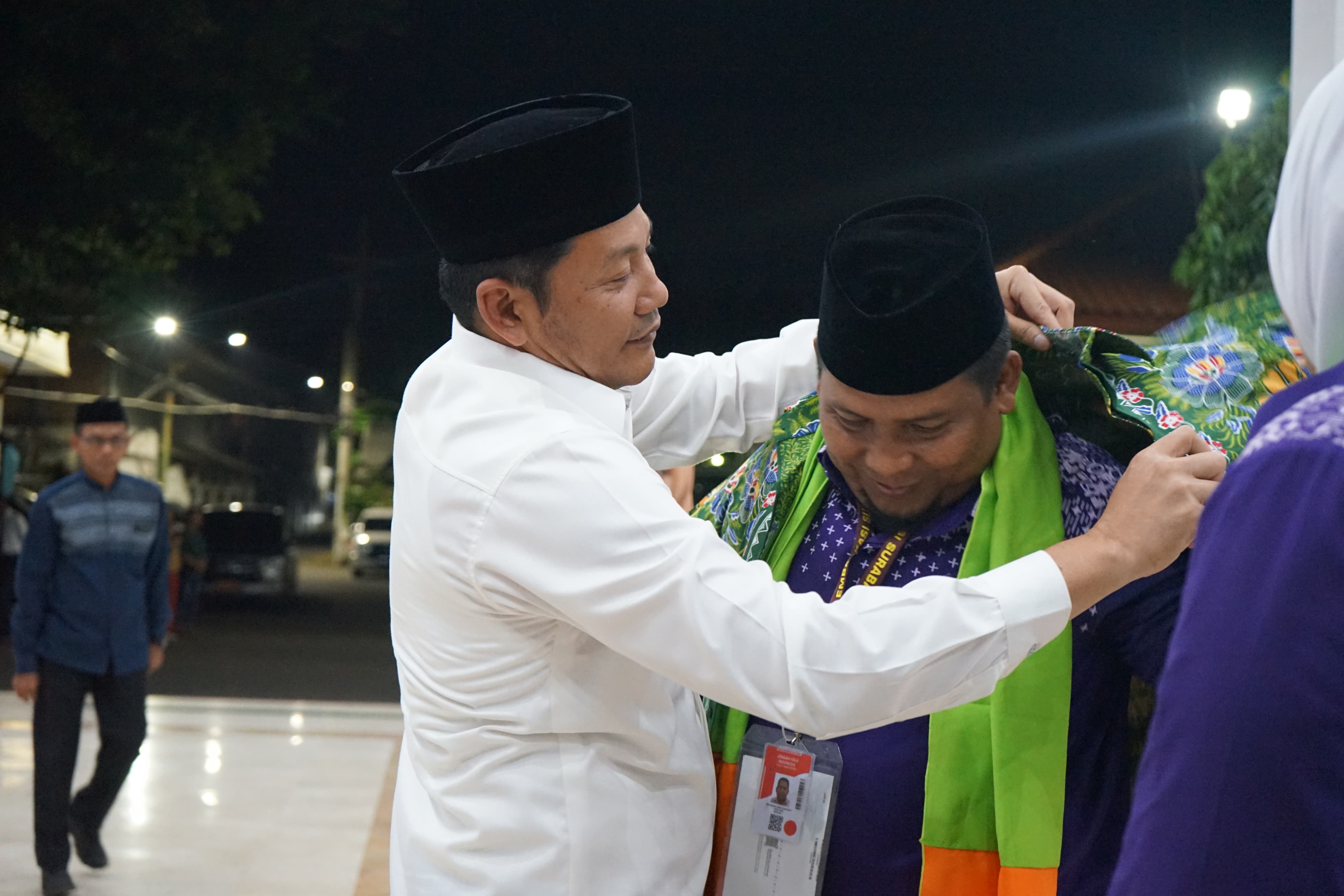 SIMBOLIS: Bupati Sidoarjo Subandi memakaikan batik ke Asisten&nbsp;Pemerintahan dan Kesejahteraan Rakyat Mohammad&nbsp;Ainur&nbsp;Rahman yang ikut berangkat haji.