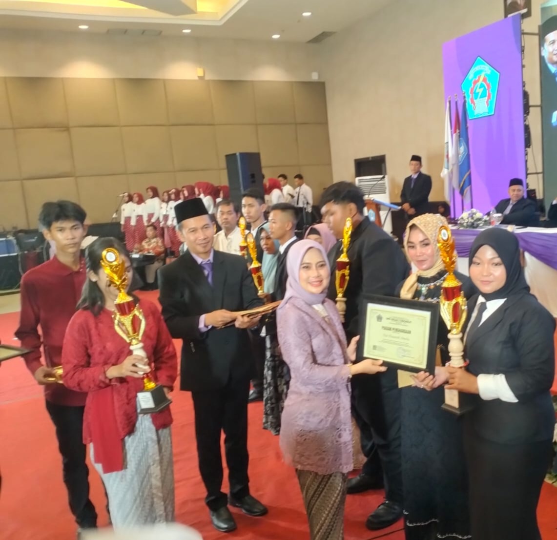 APRESIASI: Kepala SMK Krian 1 Sidoarjo Dhini Mekarsari memberikan piala siswa prestasi. (ANAS/RADAR SIDOARJO)