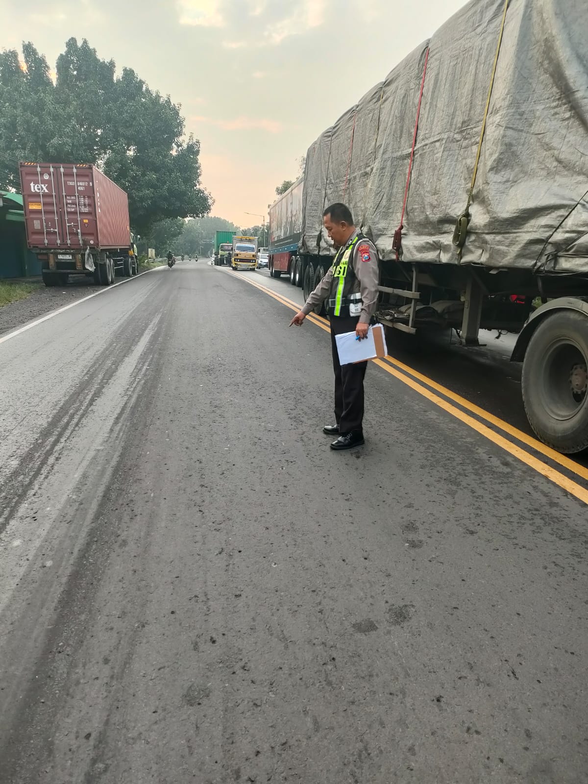 NAHAS : Polisi menunjukkan lokasi pengendara motor terjatuh usai diserempet truk di Jalan Bakungtemenggungan, Balongbendo, Sidoarjo. (IST/RADAR SIDOARJO)