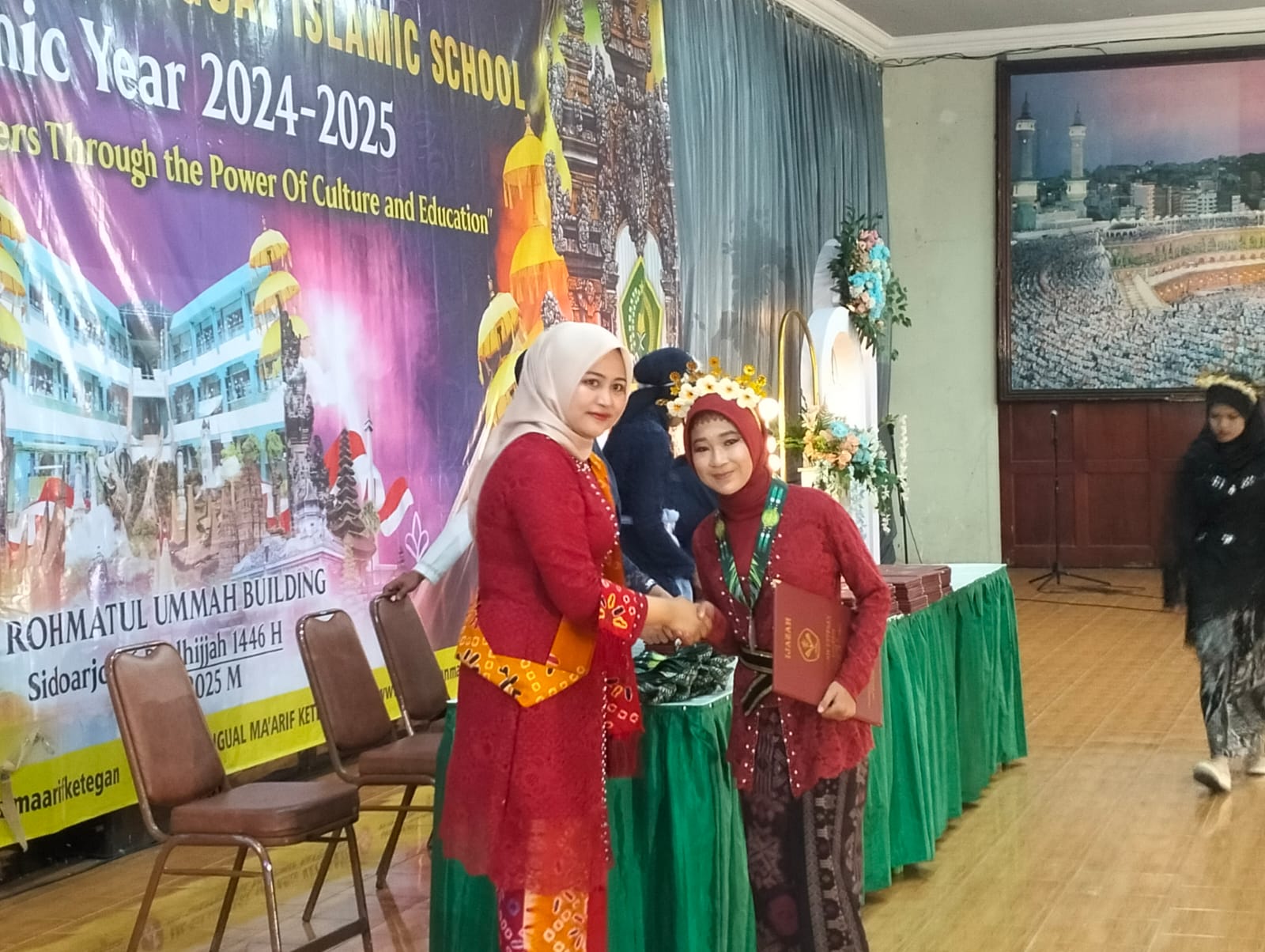 KHIDMAT: Kepala MI Ma&rsquo;arif Ketegan, Hj Umi Salamah memberikan ijazah ke salah satu siswa. (ANAS/RADAR SIDOARJO)