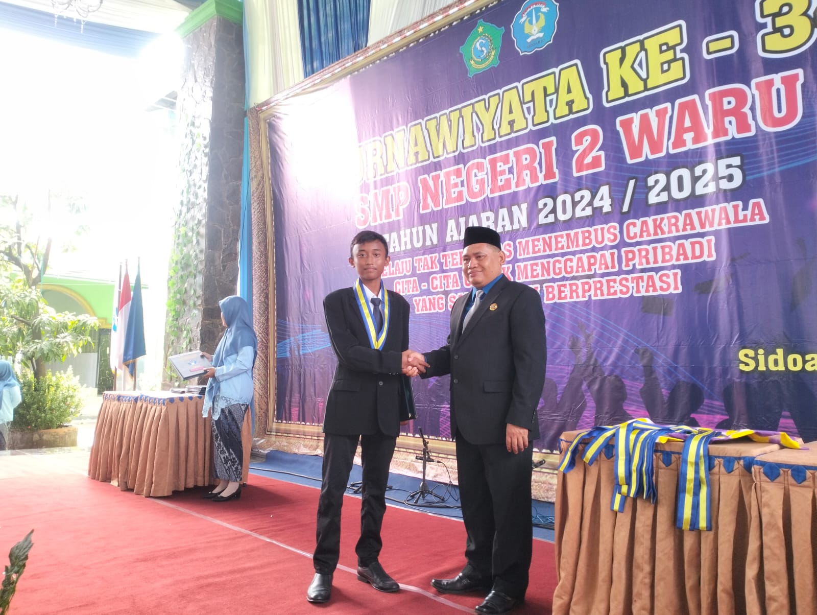 SELAMAT: Kepala SMPN 2 Waru Achmad Anwar memerikan selamat pada peserta didik. (ANAS/ RADAR SIDOARJO)