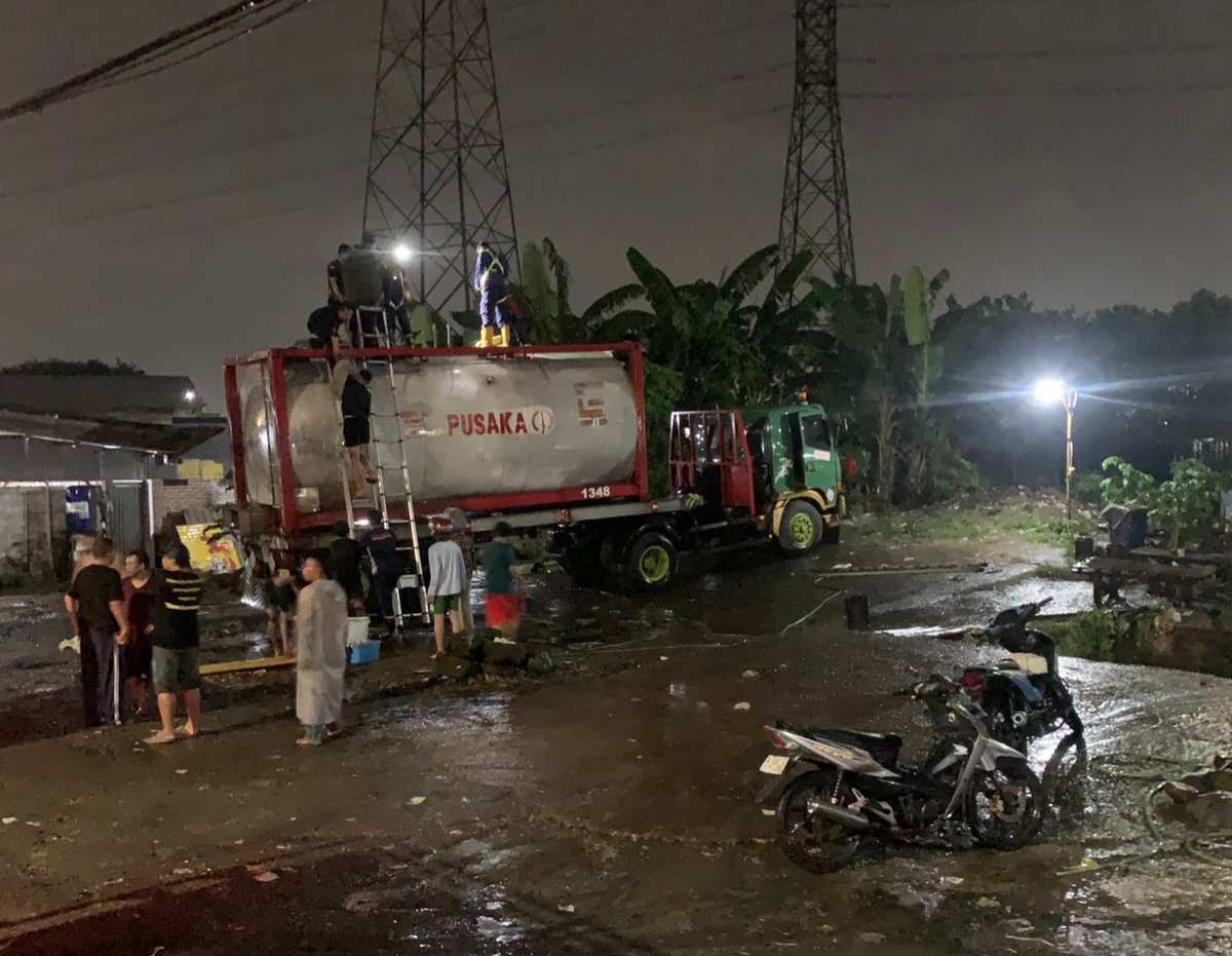 EVAKUASI : Damkar Pos Krian berupaya untuk menyelematkan korban dari dalam truk tangki di Jalan Raya Bypass Krian, Sidoarjo. Dua orang meninggal diduga keracunan residu oli bekas. (IST/RADAR SIDOARJO)