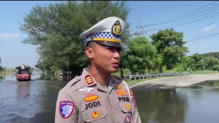 DIALIHKAN : Kasat Lantas Polresta Sidoarjo AKP Jodi Indrawan lakukan rekayasa lalu lintas di Jalan Raya Porong, Selasa (17/6). (M SAIFUL ROHMAN/RADAR SIDOARJO)