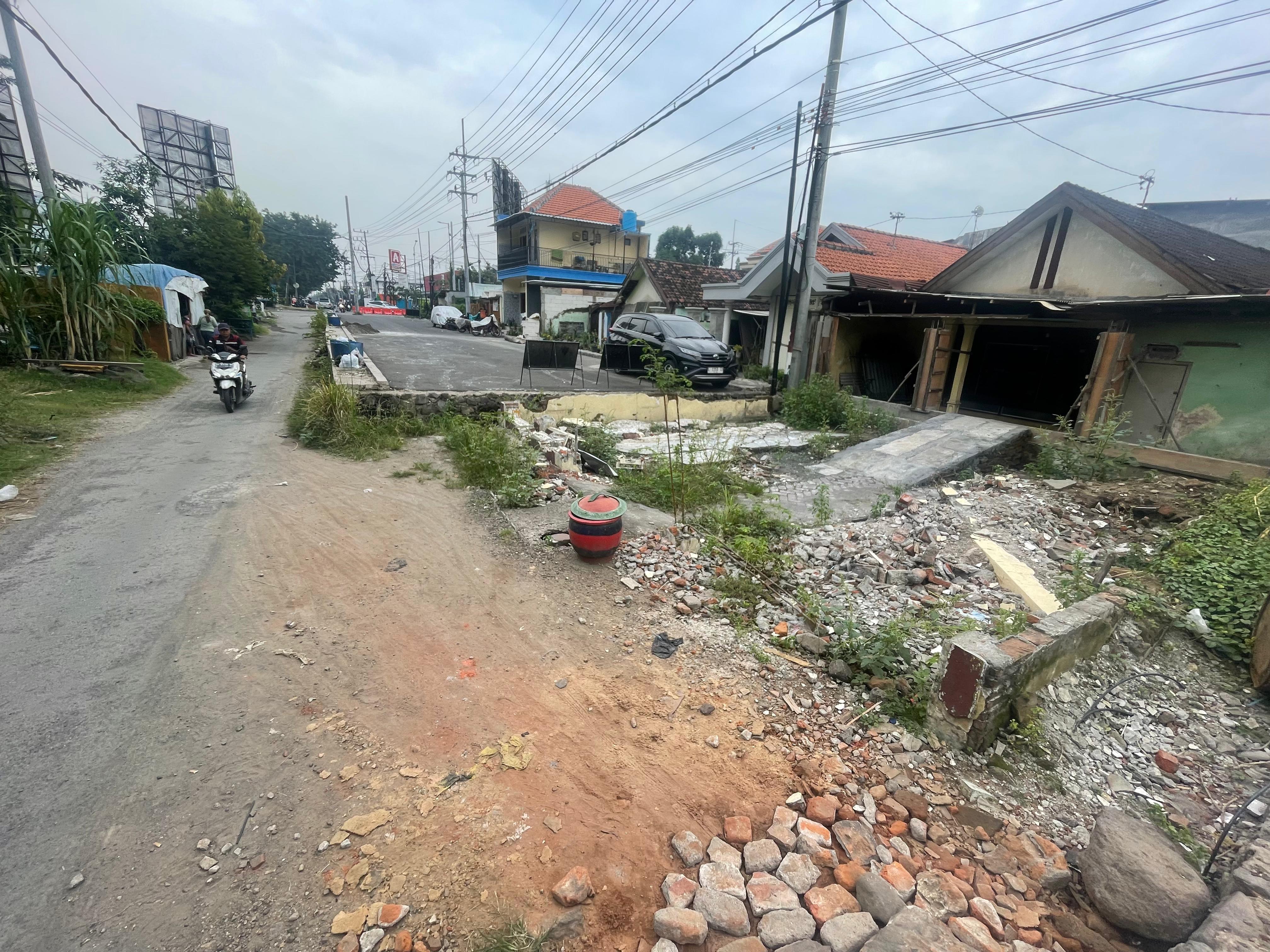 TERTUNDA: Satu lahan Frontage Road bekas rumah belum tersambung, rencananya akan dilakukan pengerasan (M SAIFUL ROHMAN/RADAR SIDOARJO)