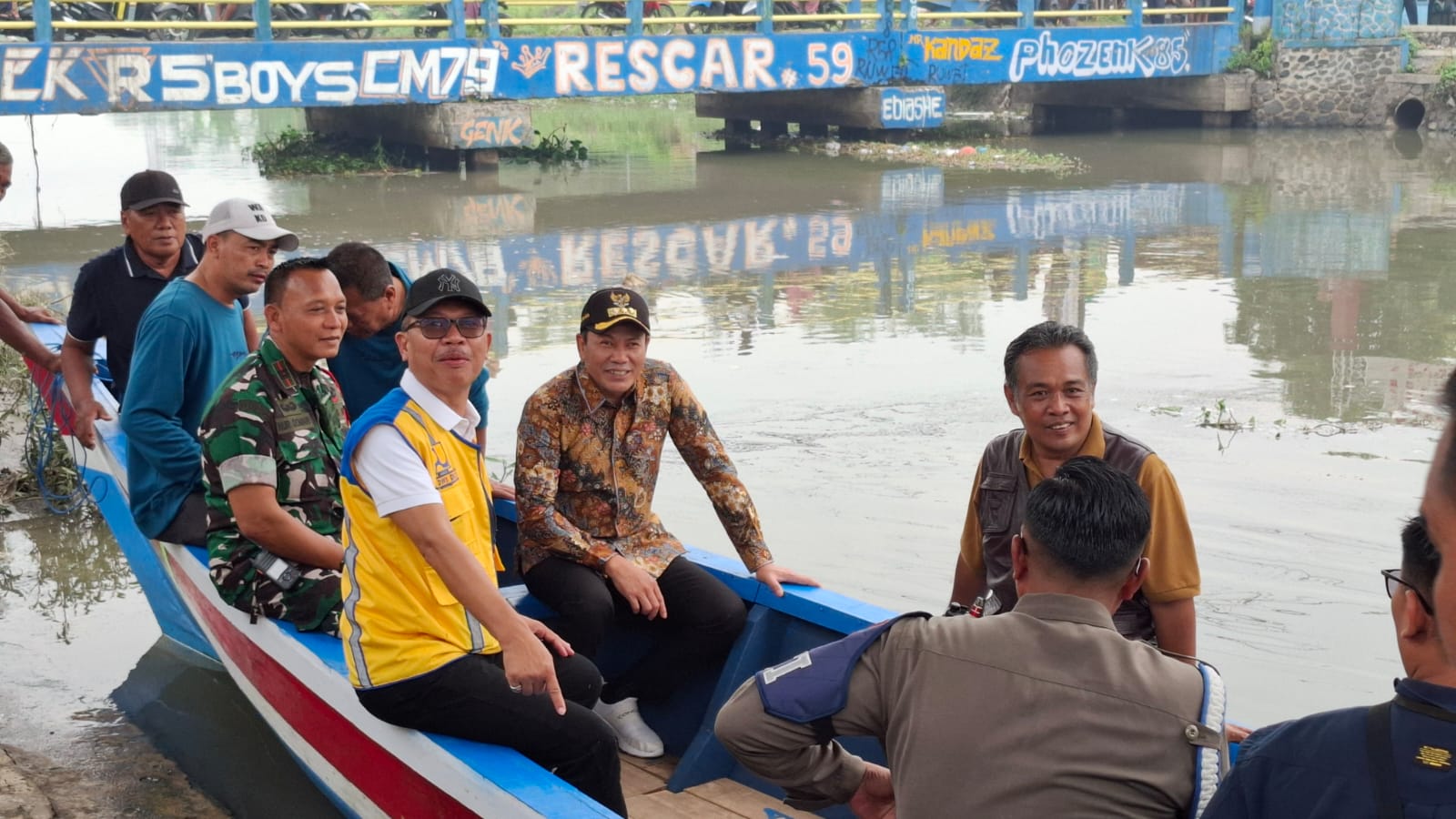 BUTUH SOLUSI: Bupati Sidoarjo Subandi (pakai batik) saat meninjau Sungai Mbah Gepuk dengan perahu. (M SAIFUL ROHMAN/RADAR SIDOARJO)
