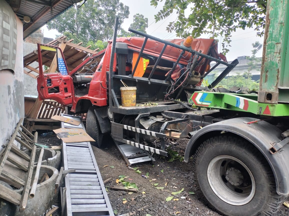APES: Truk trailer ringsek setelah menabrak gazebo di depan rumah warga hingga ringsek, Jumat (20/6).