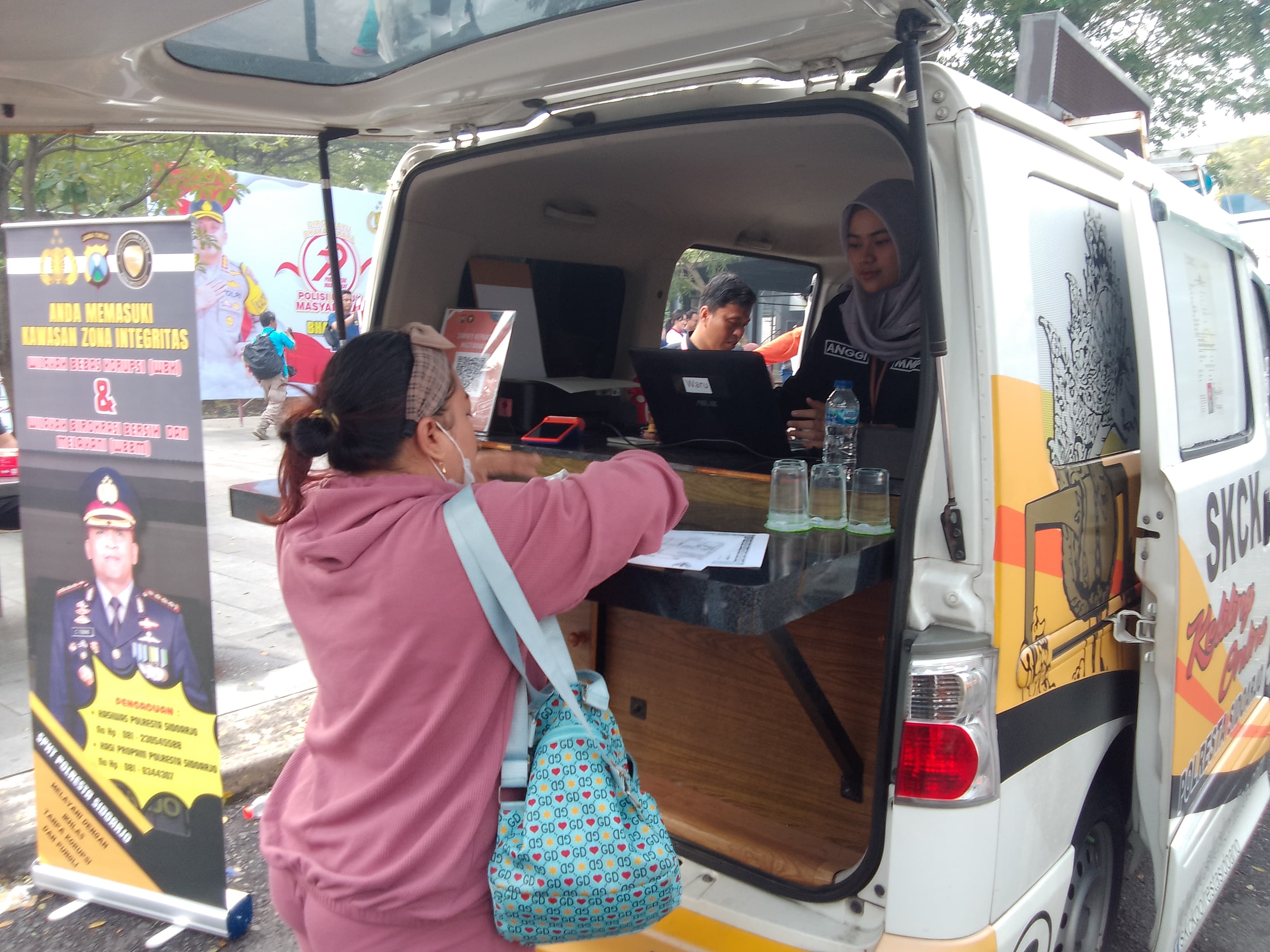 PELAYANAN : Warga sedang mengurus SKCK di mobil pelayanan publik Polresta Sidoarjo, Minggu (22/6) di Kahuripan Nirwana. (DIKY SANSIRI/RADAR SIDOARJO)