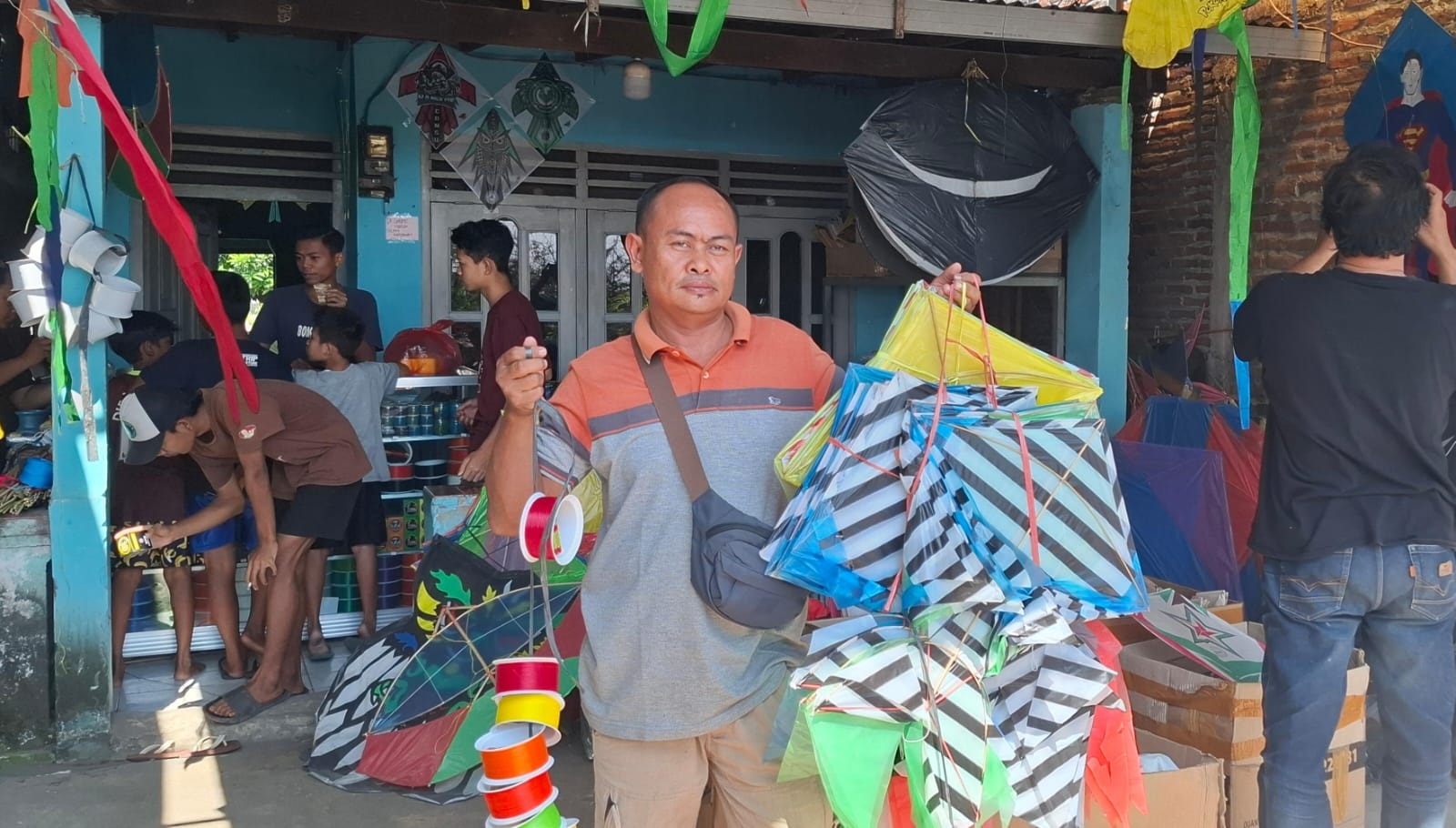 LANGSUNG BORONG: Salah satu pembeli saat memilih layang-layang. (M SAIFUL ROHMAN/RADAR SIDOARJO)