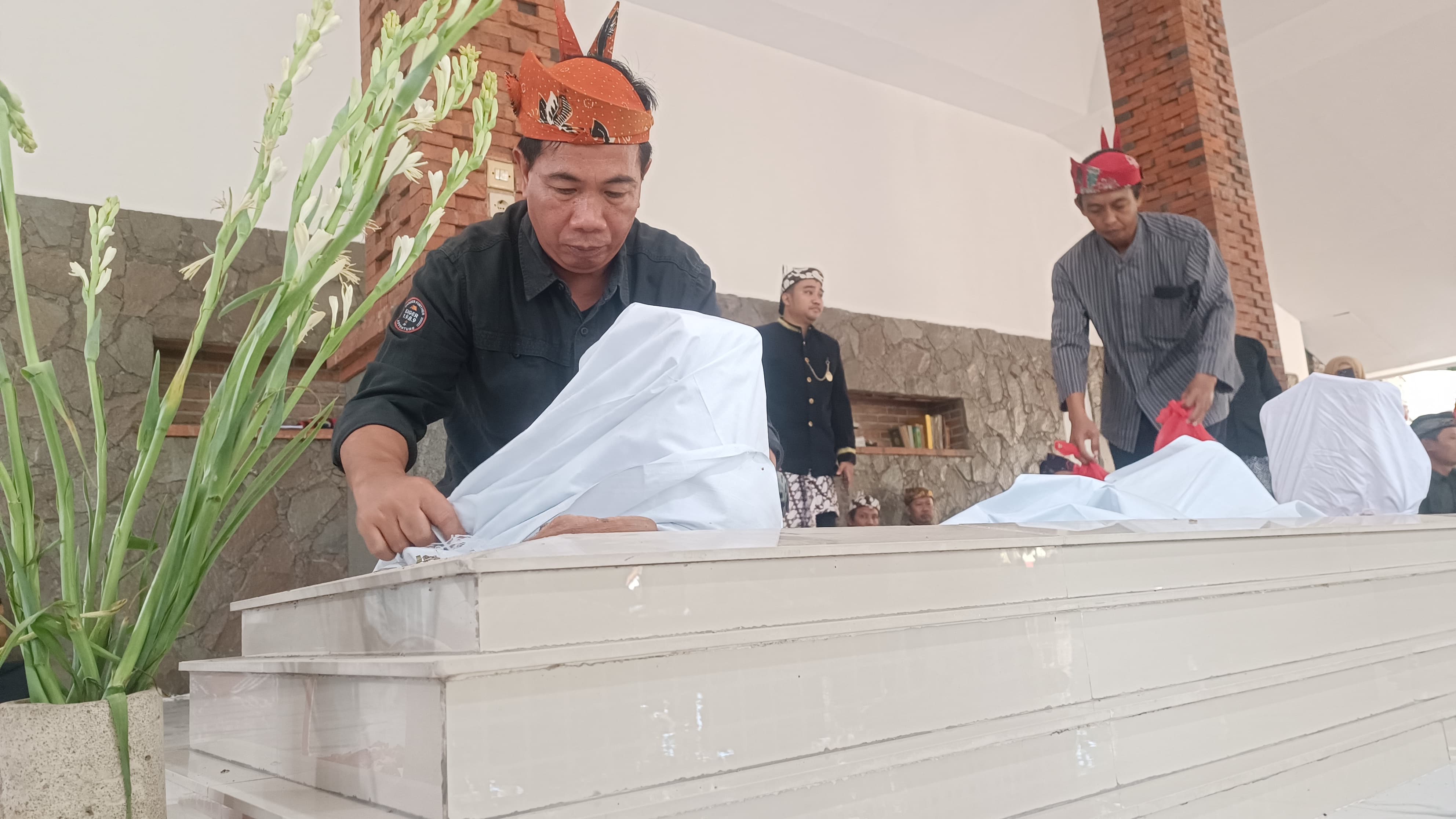 ADAT ISTIADAT: Kepala DLHK Sidoarjo M Bahrul Amig yang merupakan warga Desa Prasung saat membersihkan makam sesepuh di bulan Muharram. (M SAIFUL ROHMAN/RADAR SIDOARJO)