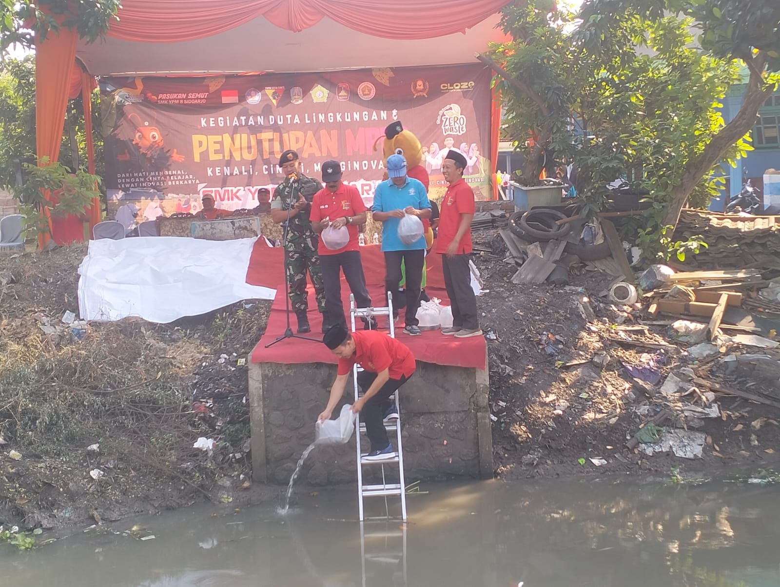 PEDULI: Ketua YPM Ahmad Makki saat tebur benih ikan didampingi kepala SMK YPM 8 Sidoarjo. (ANAS/RADAR SIDOARJO)