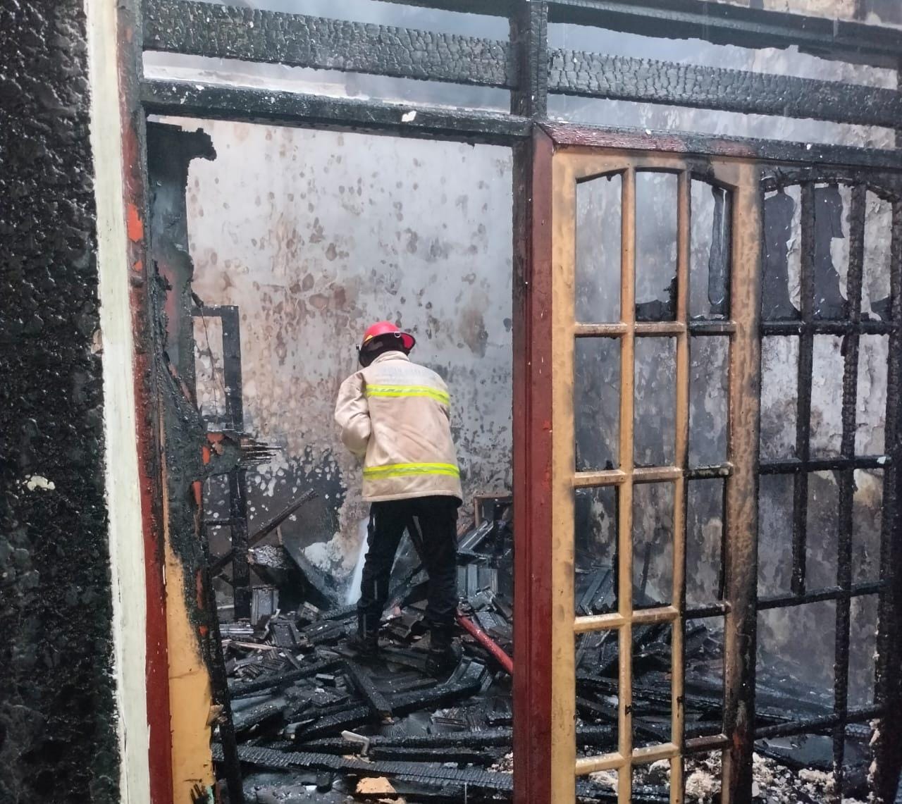 HANGUS: Petugas Damkar saat memadamkan api di Perum Makarya Binangun, Waru, Selasa (22/7). (DIKY SANSIRI/RADAR SIDOARJO)