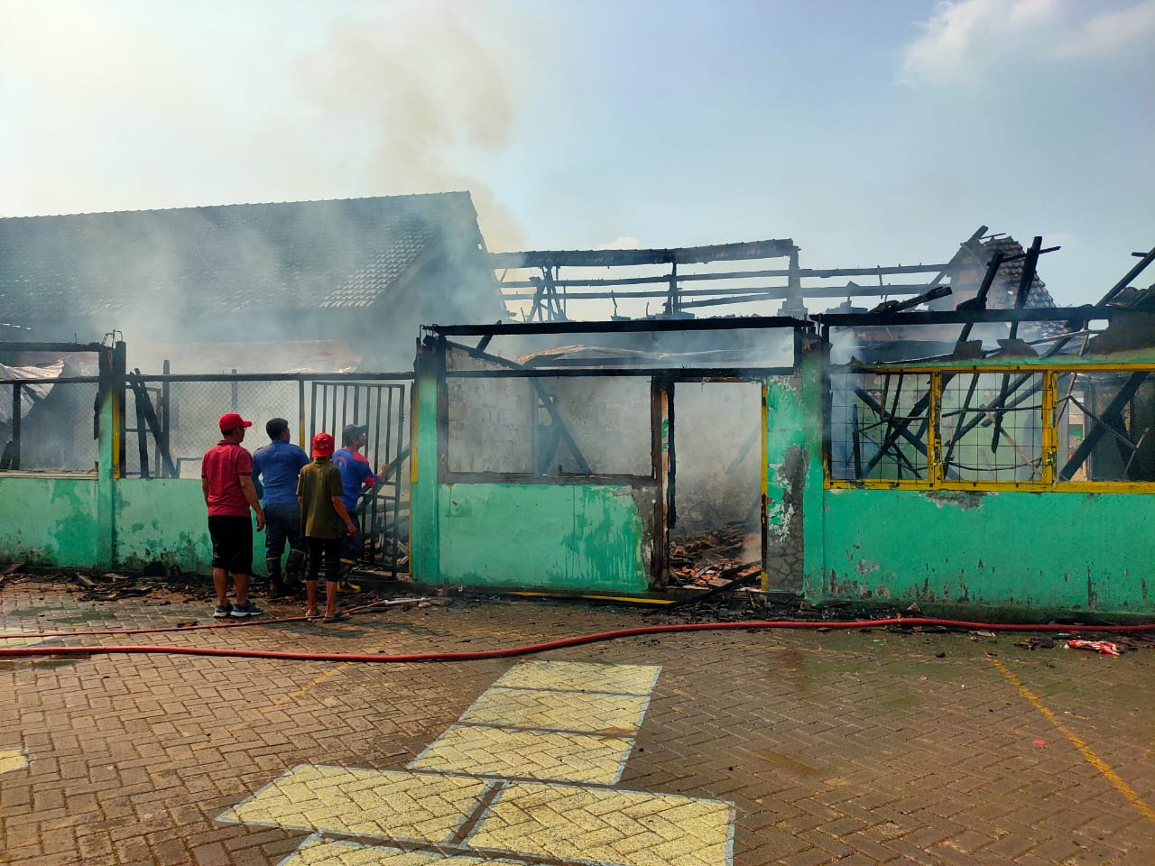 LUDES: Petugas damkar sedang berjibaku untuk memadamkan api di SDN dan TK Bendotretek Prambon, Kamis (24/7) siang.