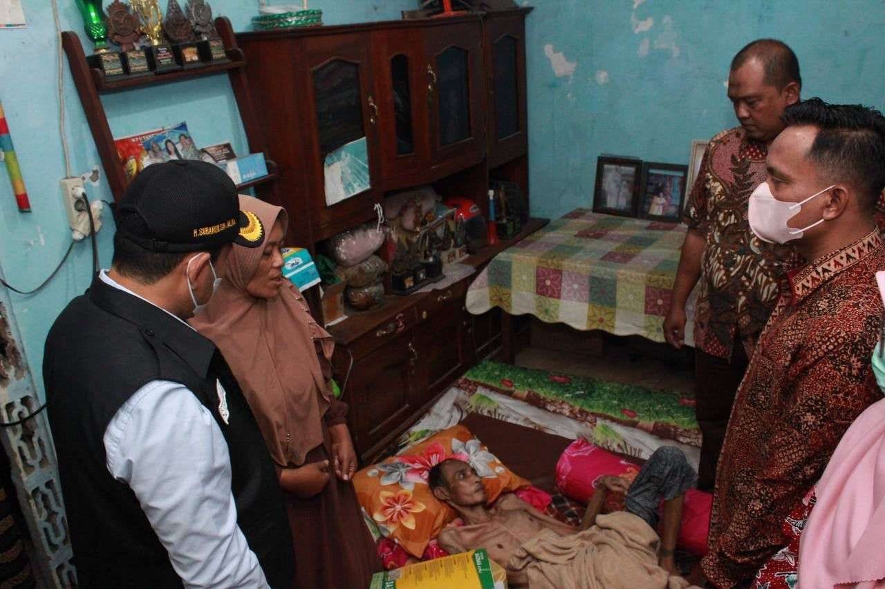 PELAYANAN KESEHATAN: Bupati Sidoarjo, Subandi saat mengunjungi salah satu warga yang sakit tumor ganas. Dinkes Sidoarjo pastikan layanan berobat gratis berjalan (IST/RADAR SIDOARJO)