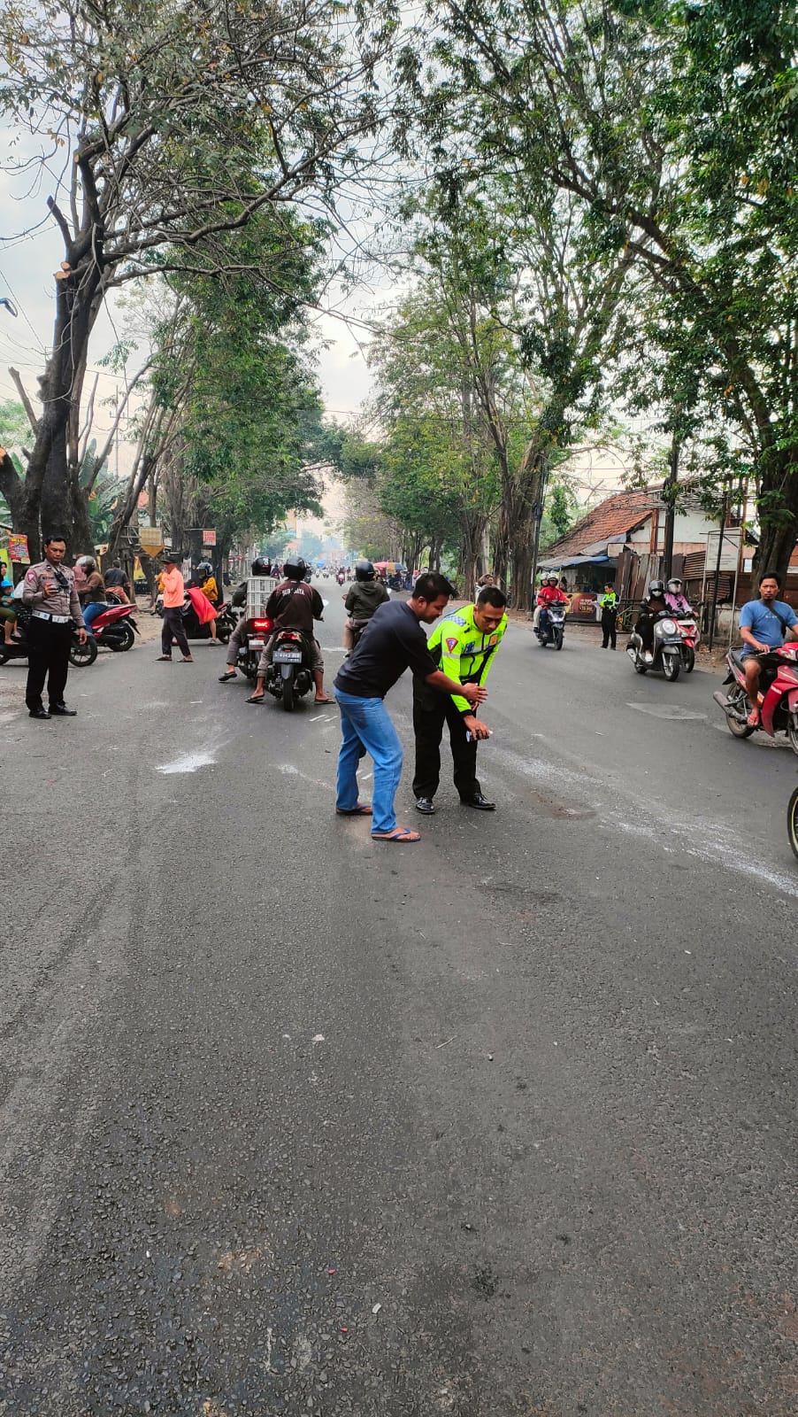 NAHAS : Polisi sedang melakukan olah TKP di Jalan Raya Kemerakan, Krian, Sidoarjo, Rabu (30/7). Korban meninggal usai diseruduk truk tangki. (IST/RADAR SIDOARJO)