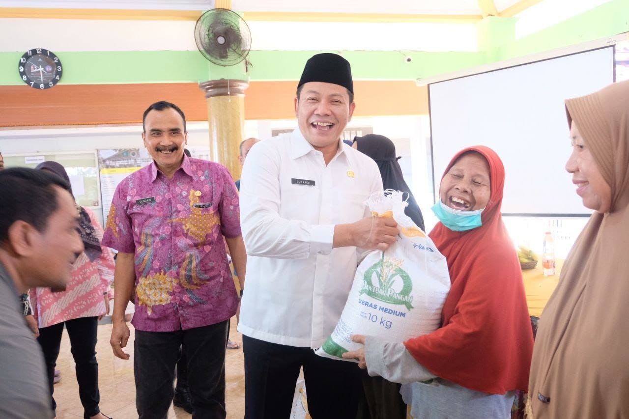 TERJUN KE LAPANGAN: Bupati Sidoarjo Subandi menyerahkan bantuan beras kepada warga Penerima Bantuan Pangan.