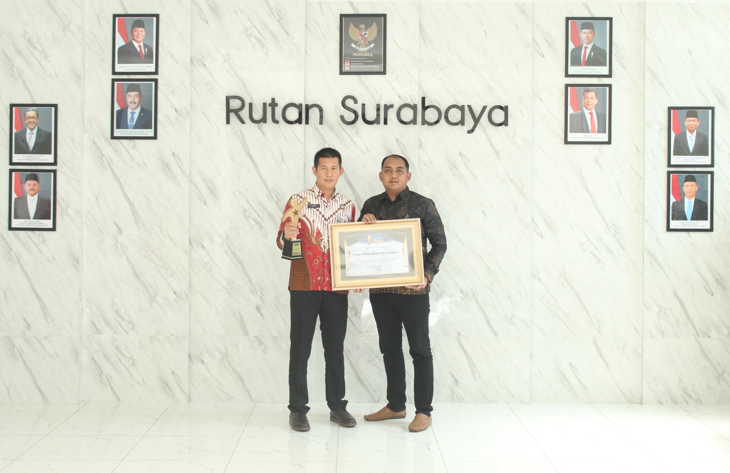 KEBERHASILAN: Kepala Rutan (Karutan) Kelas I Surabaya, Tomi Elyus bersama Kepala Kesatuan Pengamanan Rutan (Ka KPR) Hengki Giantoro menunjukkan penghargaan dari Radar Surabaya Award.