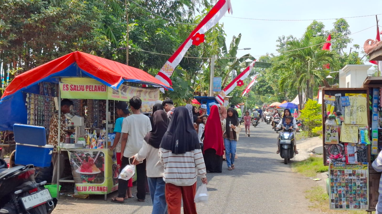 BERKAH: Warga menikmati UMKM yang ada di sekitar lokasi lomba mancing Desa Boro. (M SAIFUL ROHMAN/RADAR SIDOARJO)